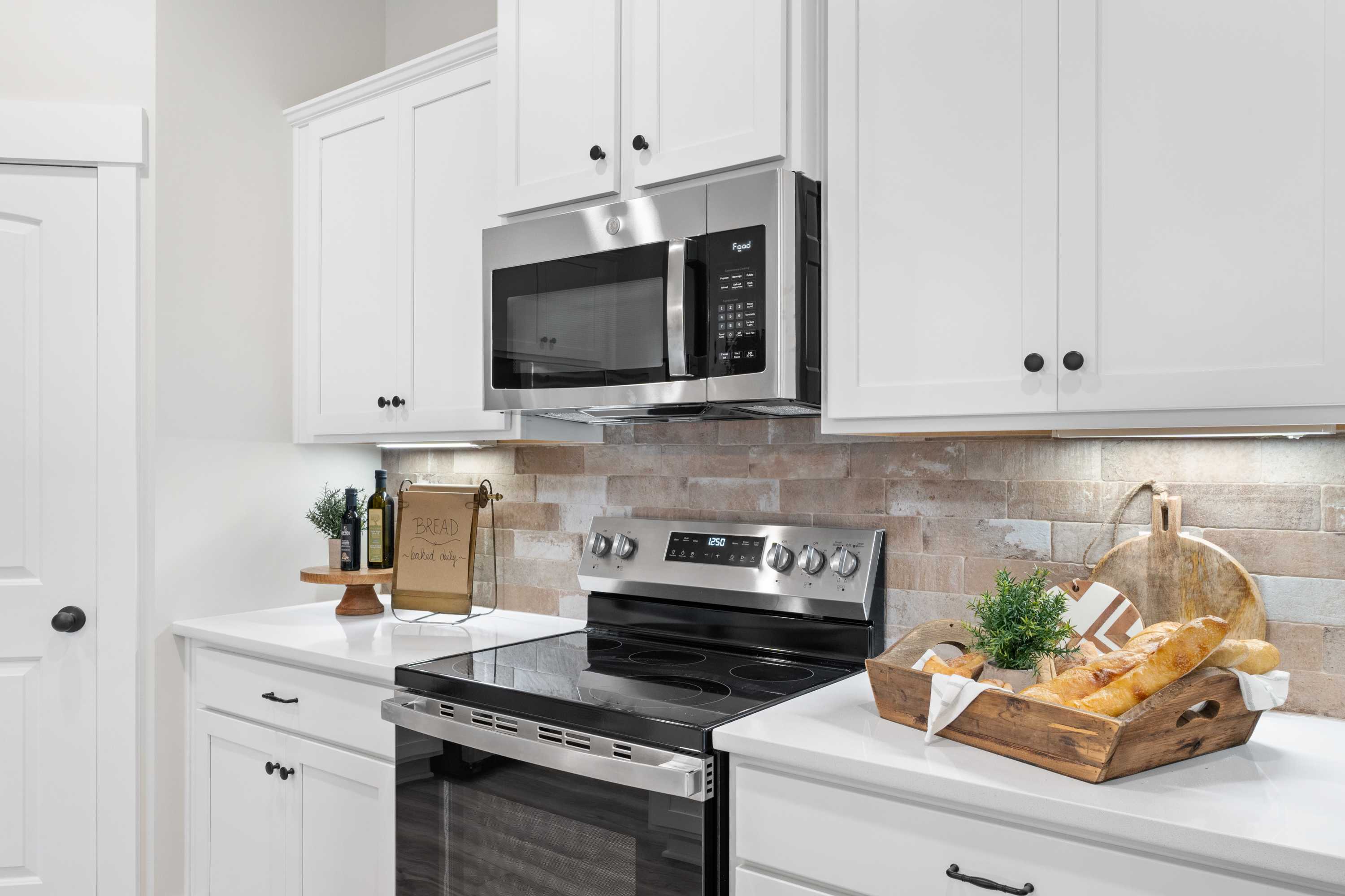 Modern kitchen in Spragins Cove Huntsville AL with white shaker cabinets, stainless steel appliances, subway tile backsplash