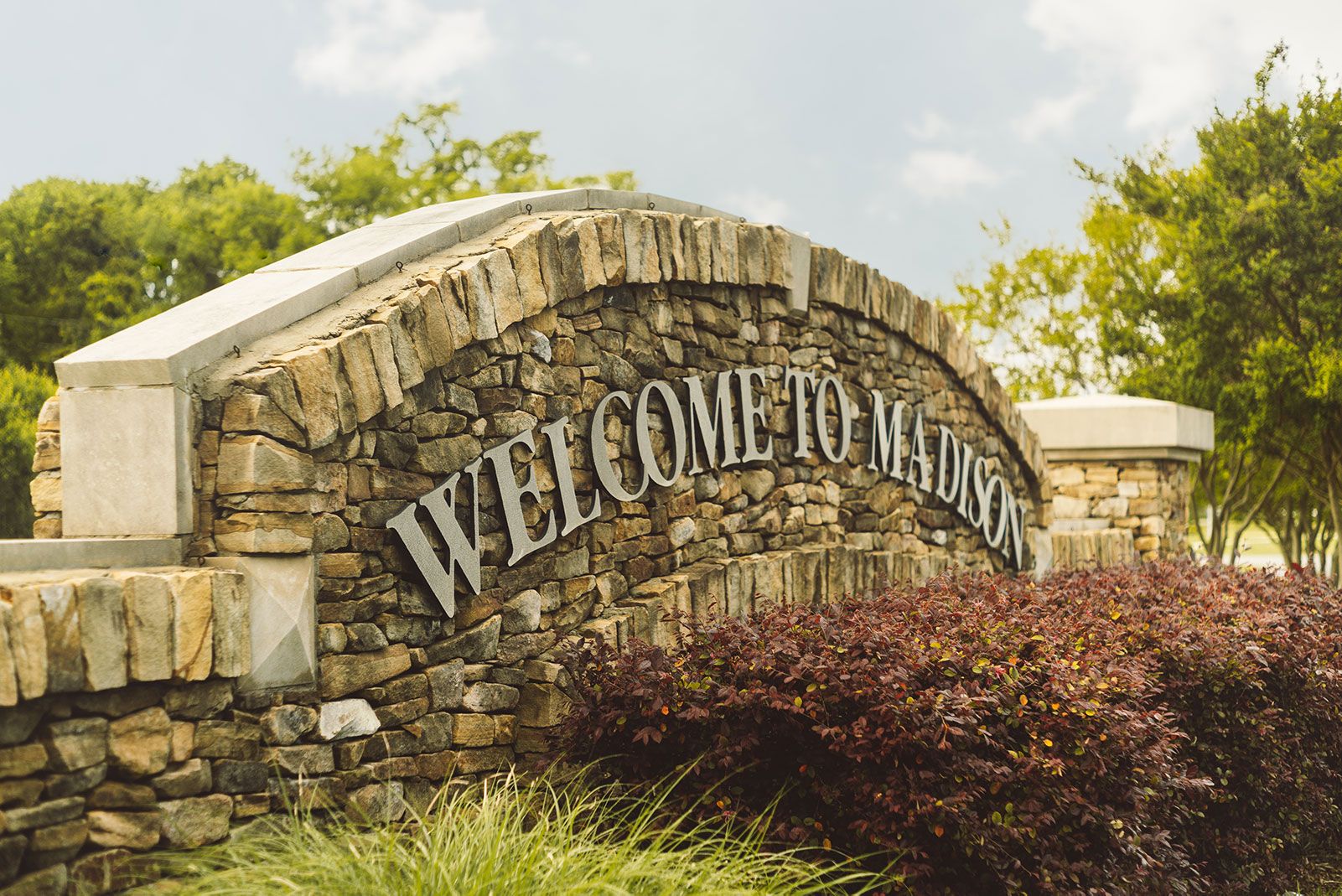 Welcome to Madison stone archway sign at Brookhaven community in Madison Alabama with lush greenery