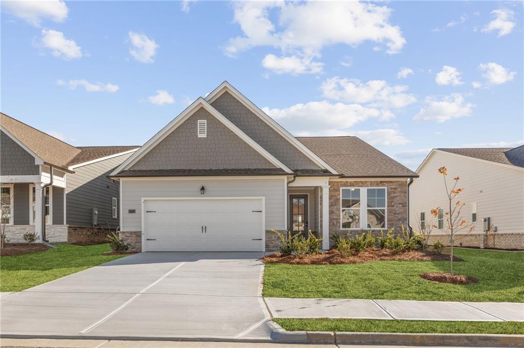 Modern single-story 3-bedroom home with 2-car garage, stone accents, and landscaped yard in Kelly Preserve, Loganville, Georgia by Davidson Homes The Glenwood A