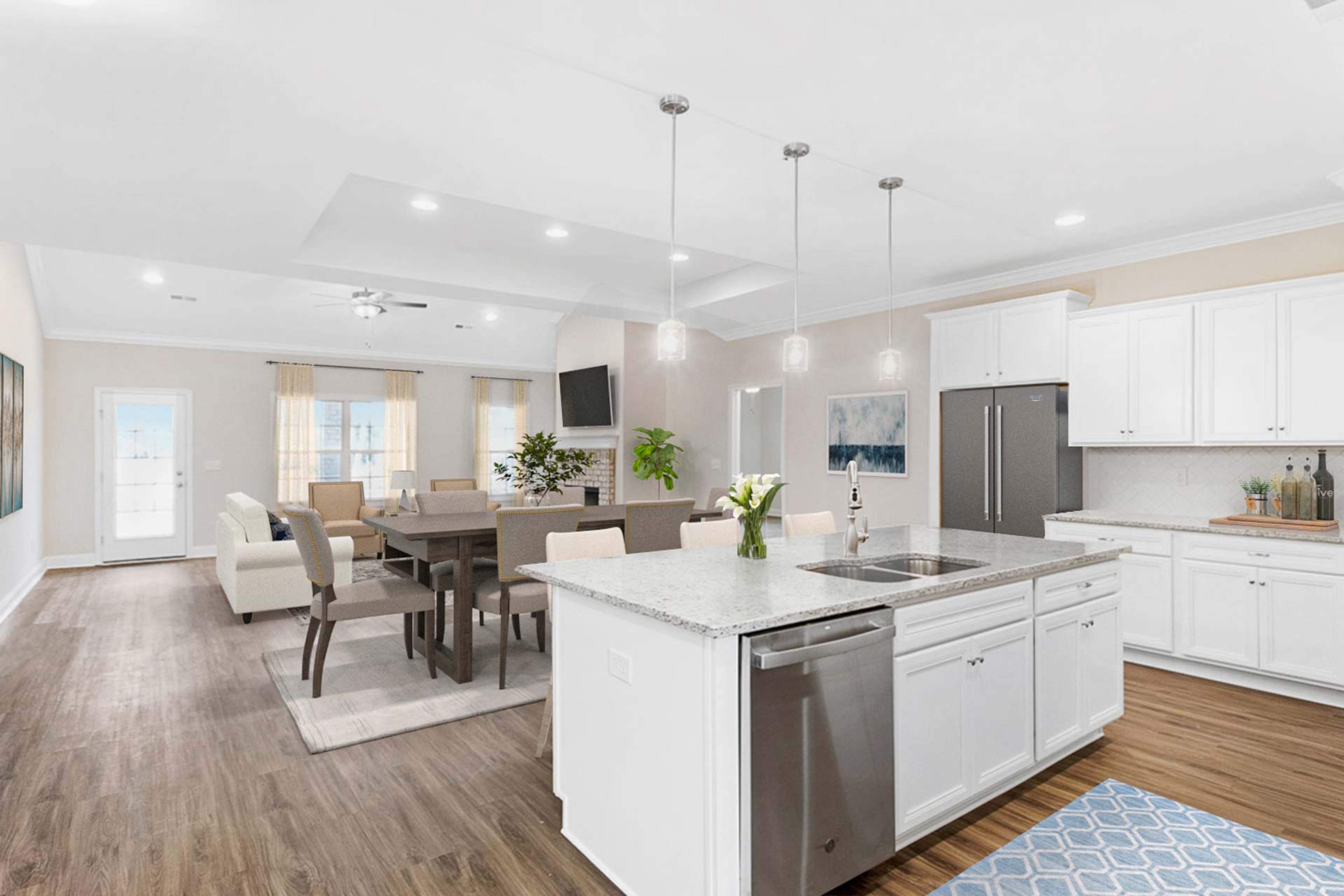 Spacious open-concept kitchen dining living area at Huntington Park in Priceville Alabama with white island hardwood floors