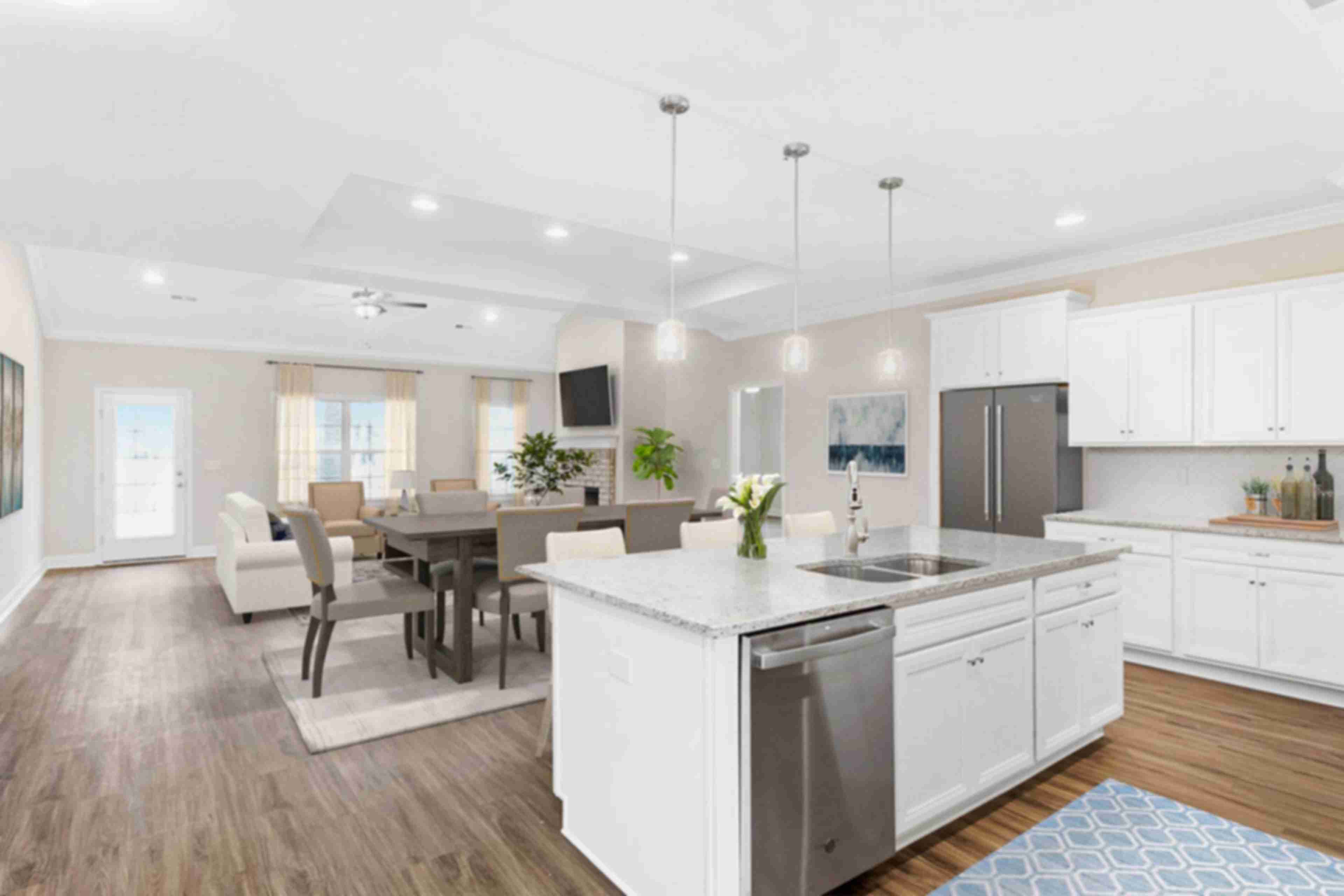 Spacious open-concept kitchen dining living area at Huntington Park in Priceville Alabama with white island hardwood floors