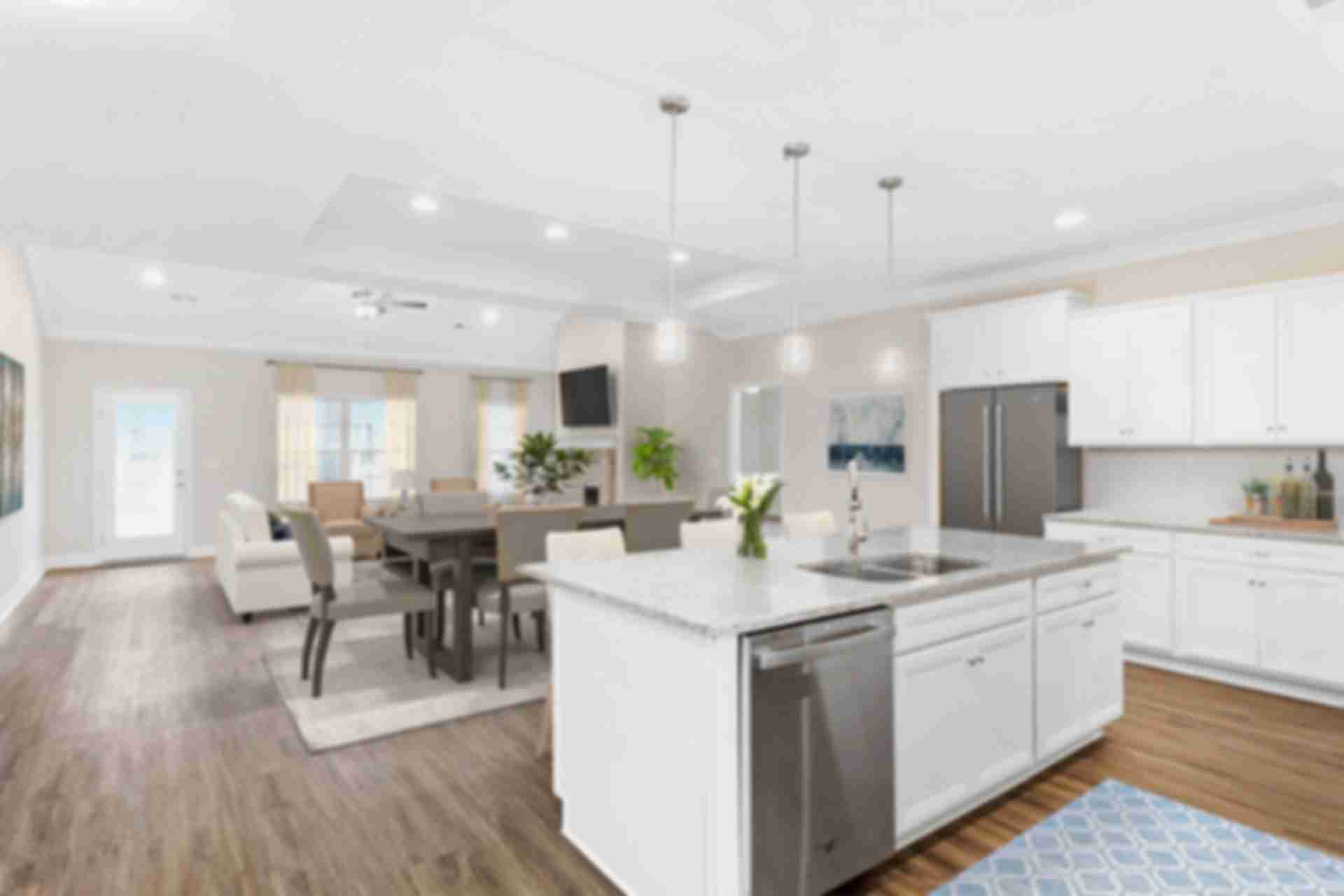 Spacious open-concept kitchen dining living area at Huntington Park in Priceville Alabama with white island hardwood floors