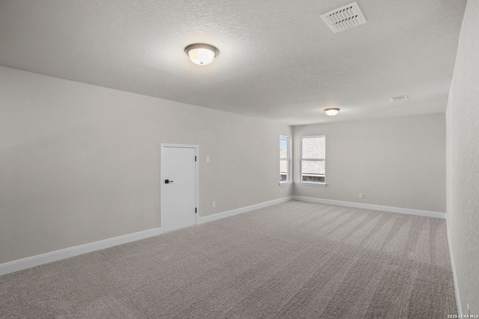 Spacious carpeted bedroom with neutral walls in The Jennings G floor plan by Davidson Homes in Ladera, San Antonio, Texas.