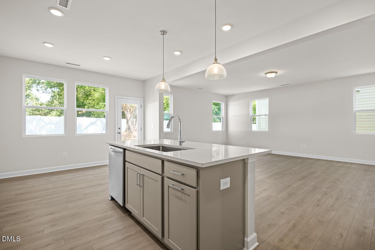 Open-concept kitchen island with quartz countertops in The Gavin A floor plan at Gregory Village, Lillington, NC.
