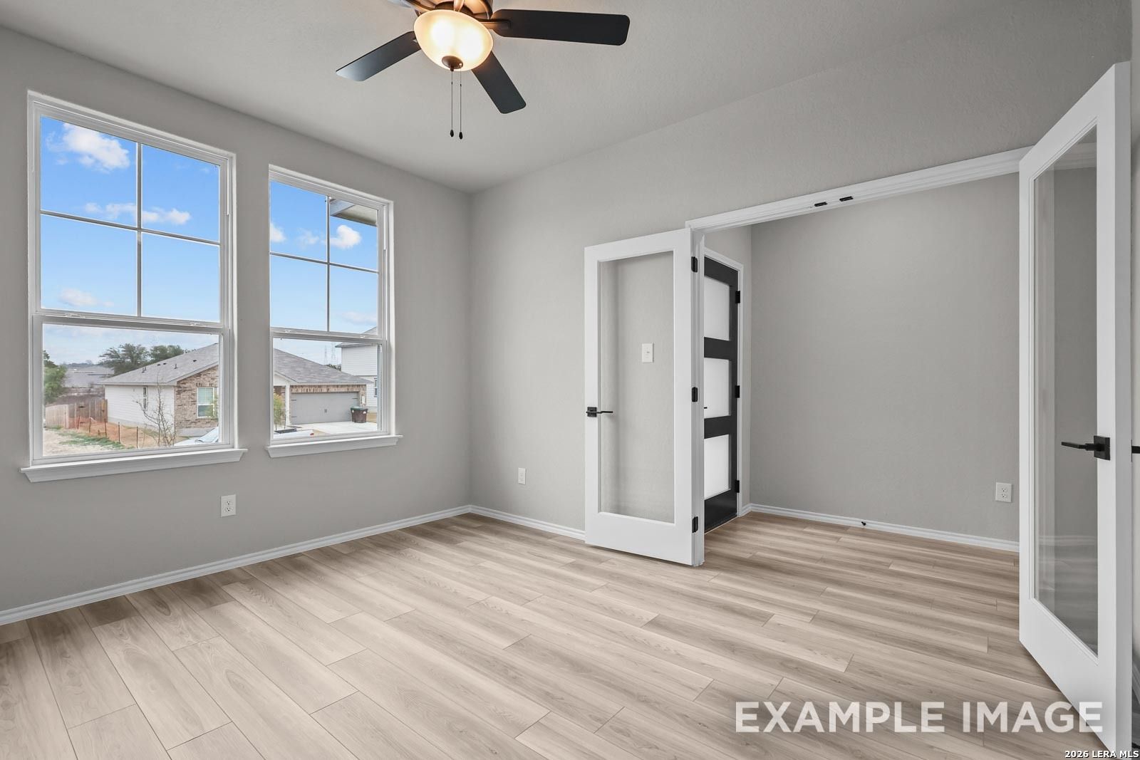 Bright home office with glass French doors and wood-look flooring in The Glenwood E floor plan, Royal Crest, San Antonio.