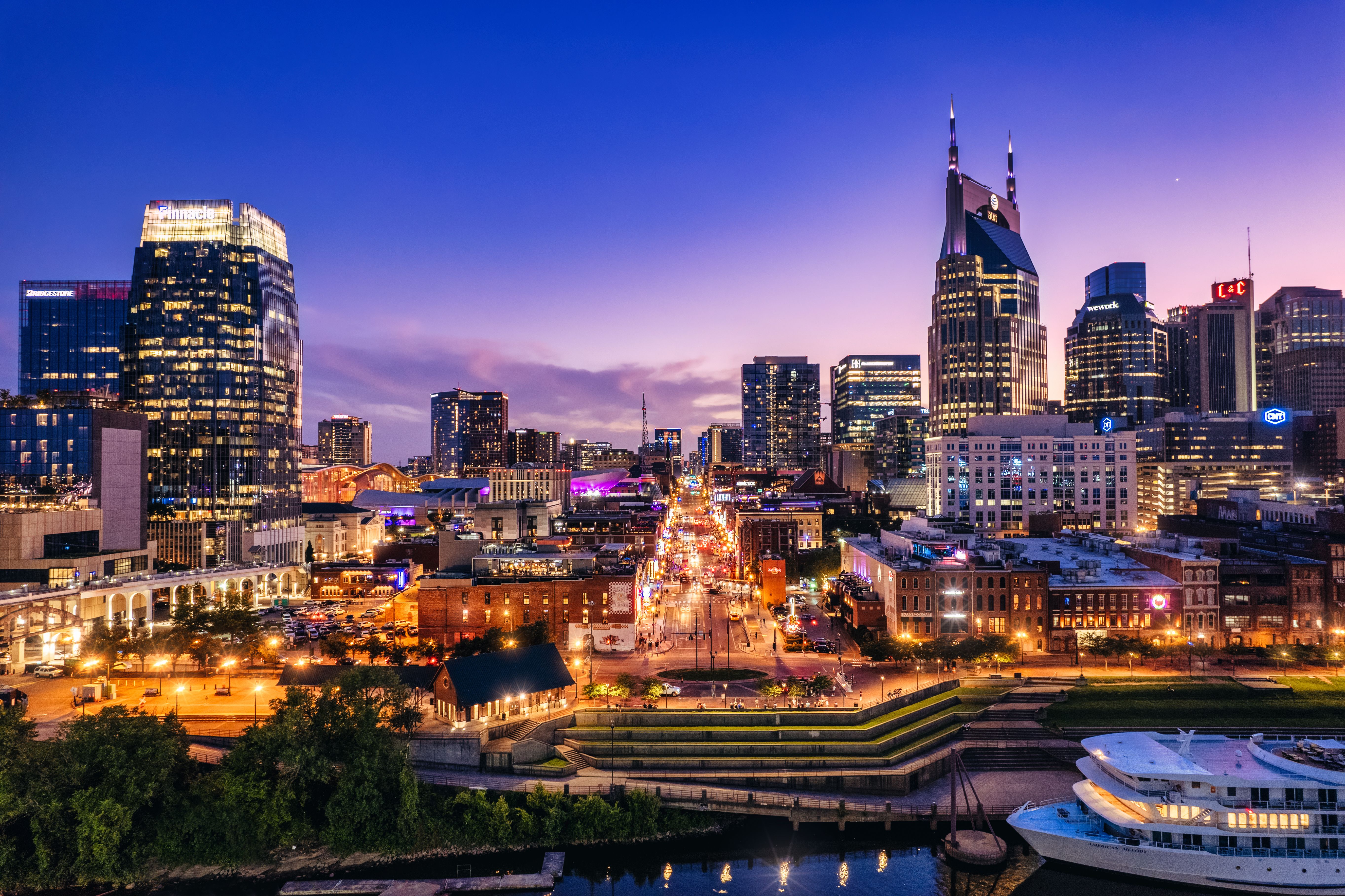 Nashville city skyline at dusk with the Cumberland River and illuminated skyscrapers near Jackson Village.