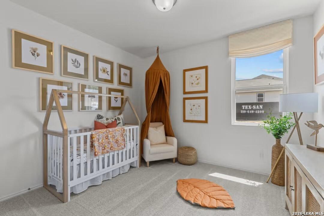 Charming nursery with canopy crib, botanical wall art, and cozy armchair in The Daphne H 3-bedroom home, Seguin, Texas