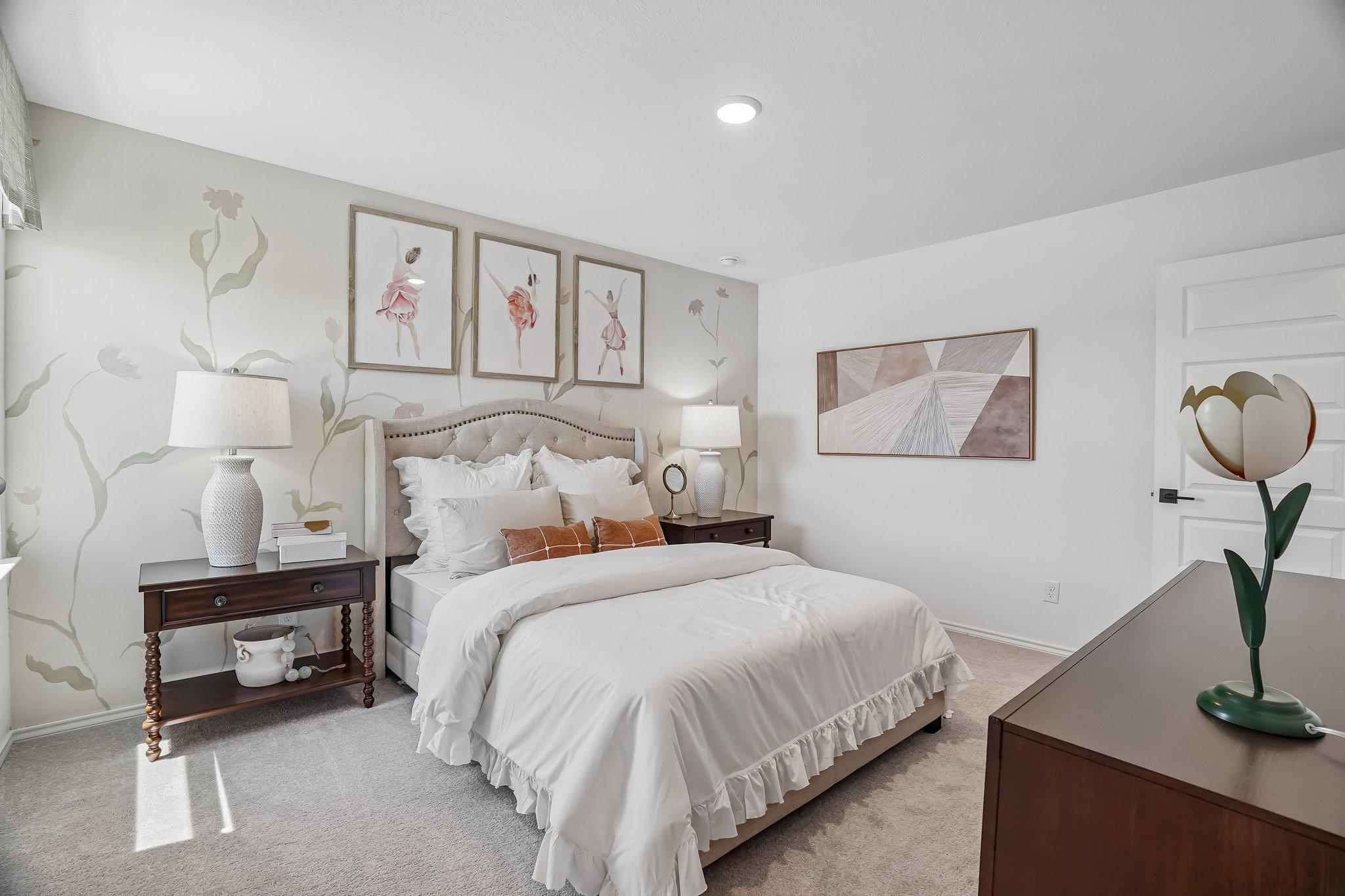 Cozy bedroom with floral wall mural and tufted headboard at Fairway Crossing in Converse, Texas by Davidson Homes.