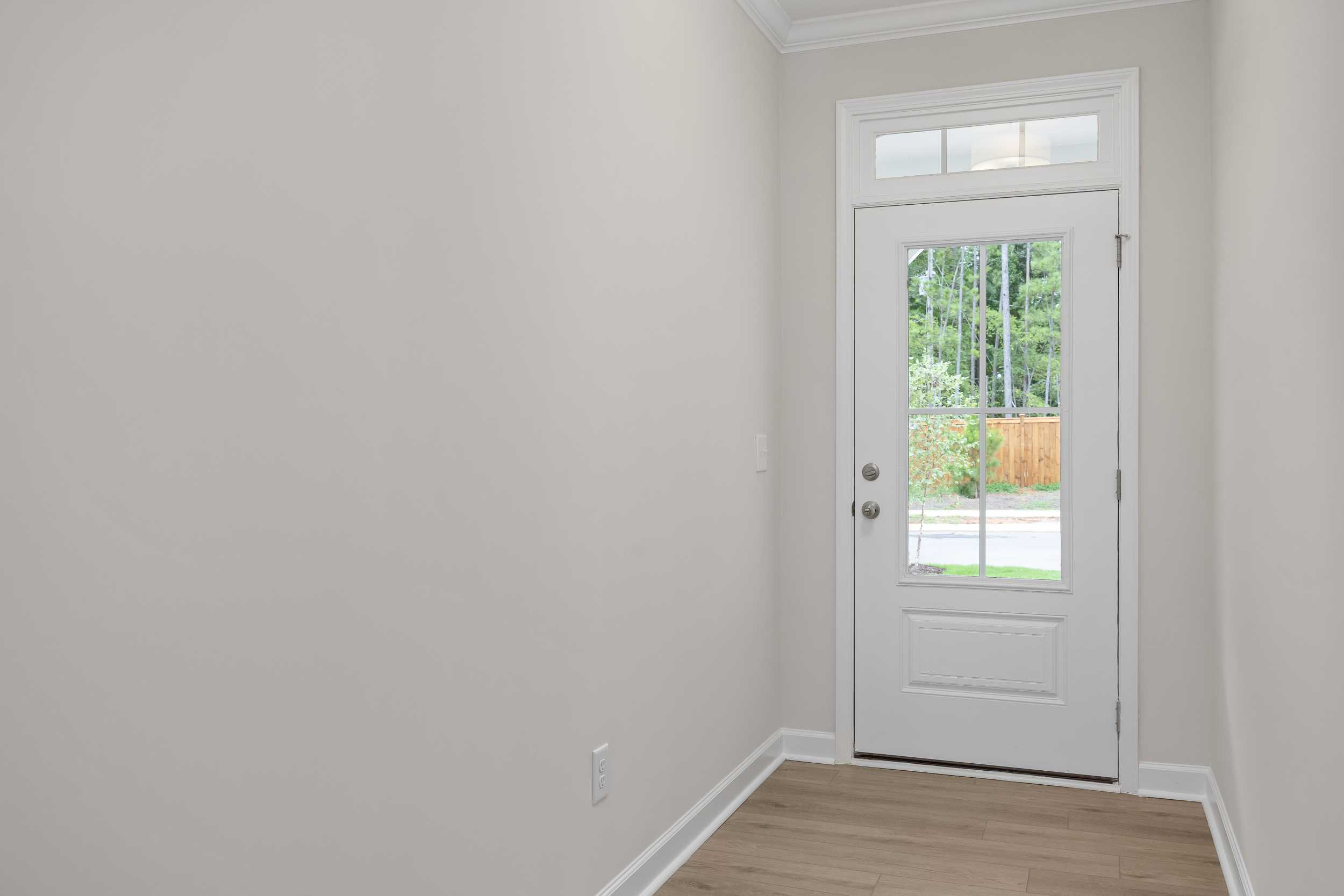 Hallway interior in The Beech C home design with glass-paneled back door to fenced yard, gray walls, hardwood floors