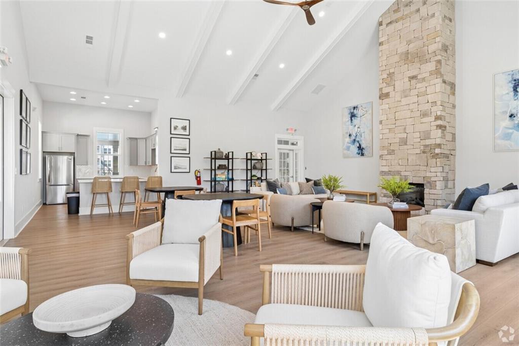 Vaulted-ceiling clubhouse lounge with stone fireplace and kitchenette at Davidson Homes Stegall Village community in Emerson, Georgia