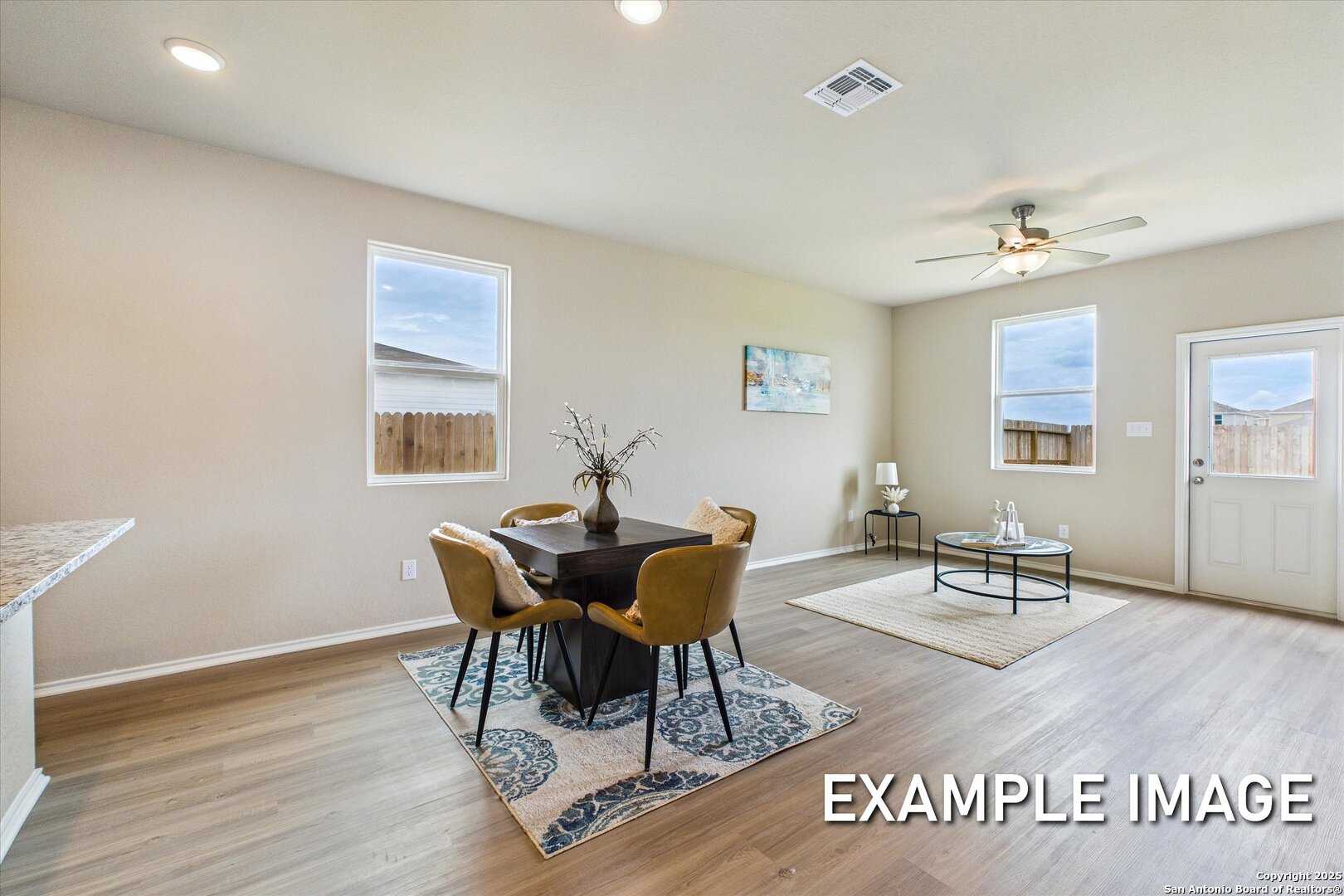 Modern dining nook with square table, upholstered chairs, and ceiling fan in The Comal B by Davidson Homes, Agave, San Antonio
