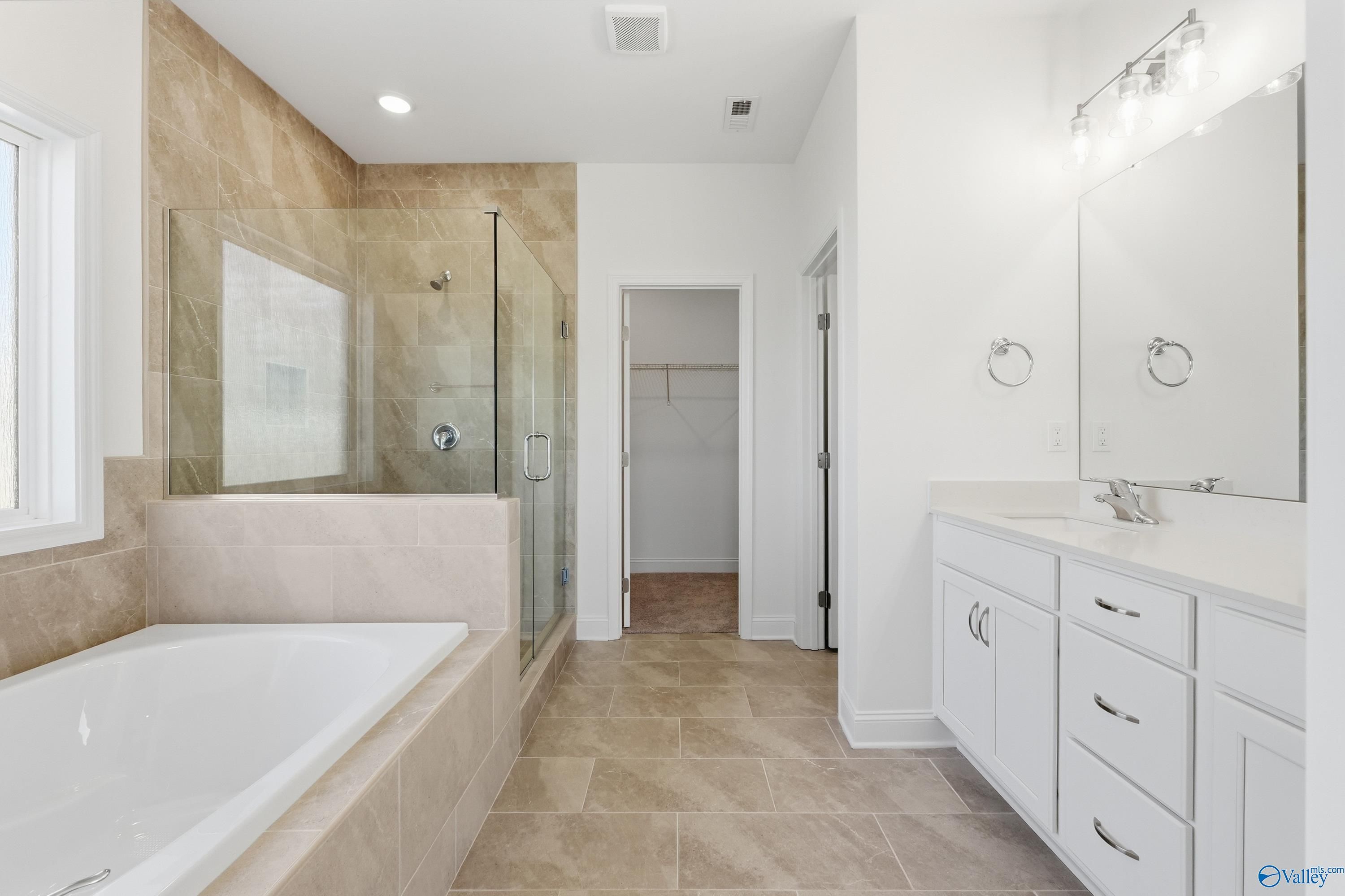 Luxurious master bathroom featuring glass shower, freestanding tub, and double vanity in Davidson Homes The Montgomery, Meridianville, Alabama