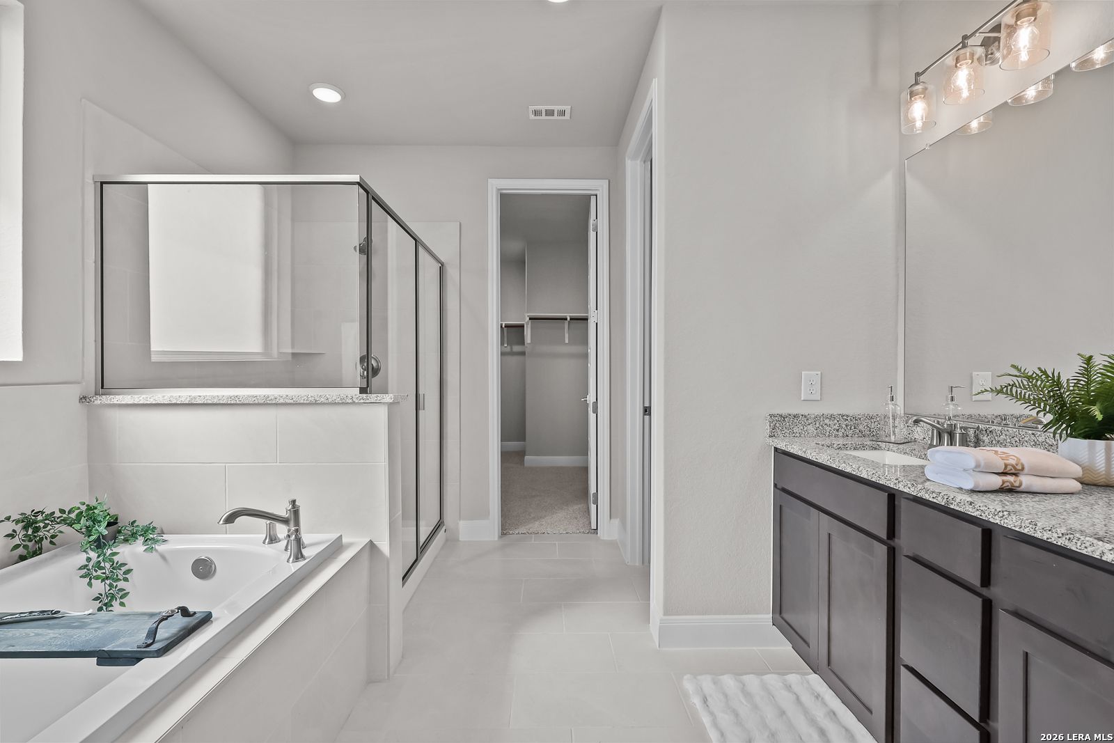 Elegant master bathroom featuring freestanding tub, glass shower, double vanity with granite in Davidson Homes The Rockford G, Ladera, San Antonio