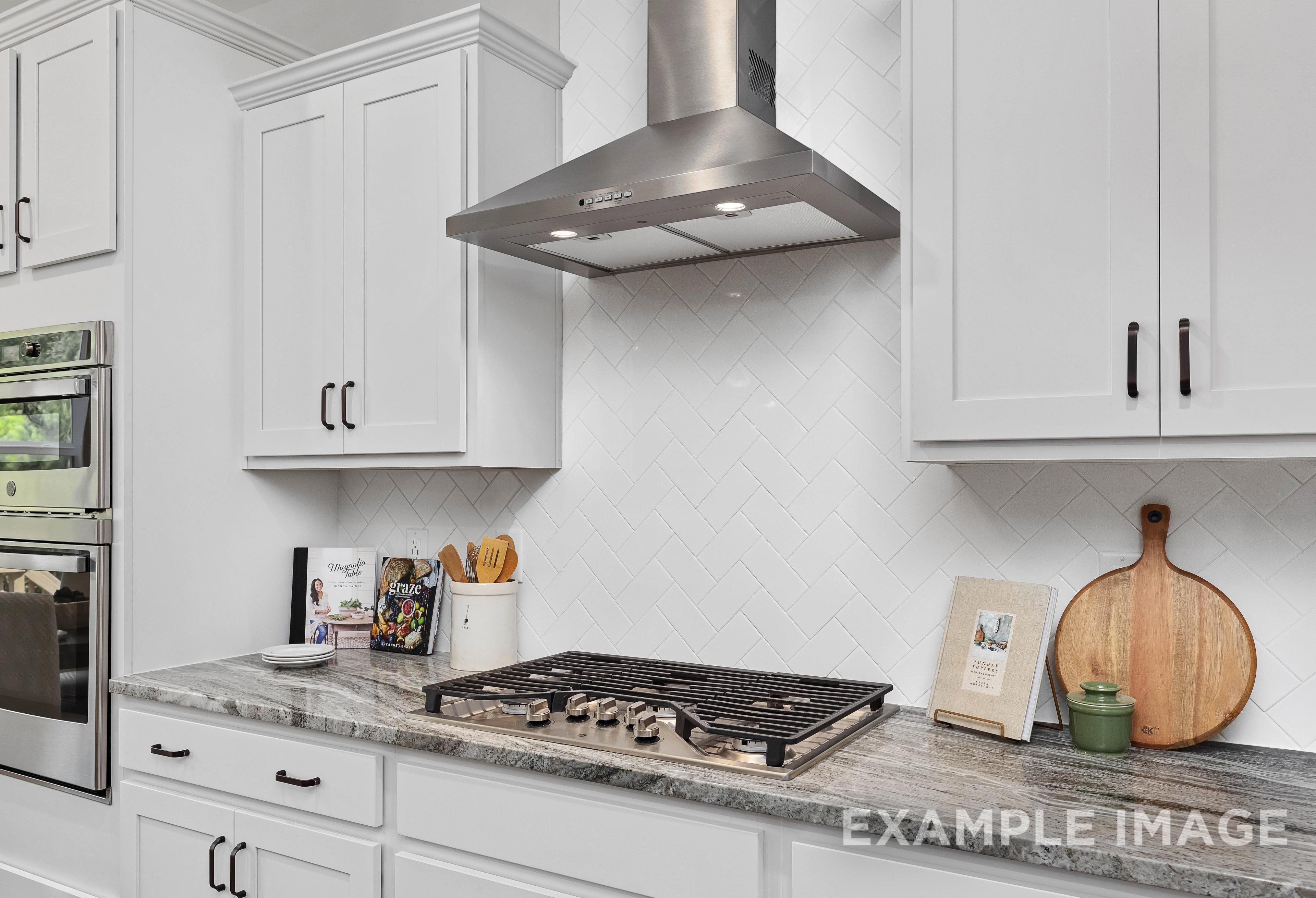 Modern kitchen in The Willow B featuring white shaker cabinets, stainless steel gas cooktop, and subway tile backsplash