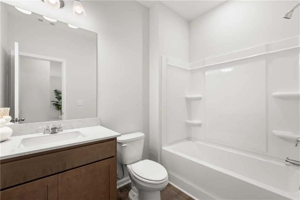 Modern bathroom with white tub-shower combo and vanity in The Sinclair B floor plan at Cedar Farms in Winder, Georgia.