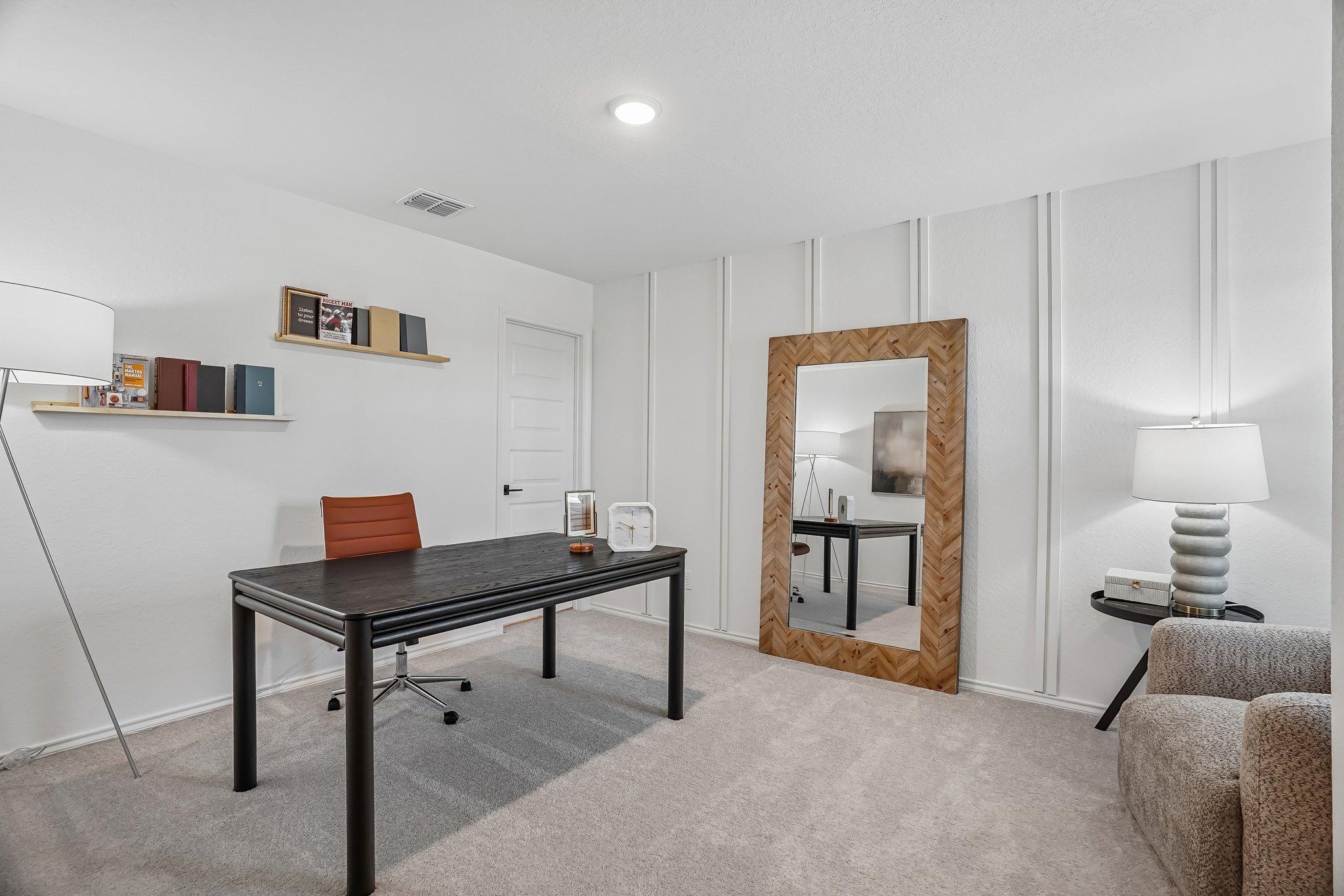 Modern home office at Fairway Crossing in Converse, TX featuring black desk, herringbone mirror, and board-and-batten walls.