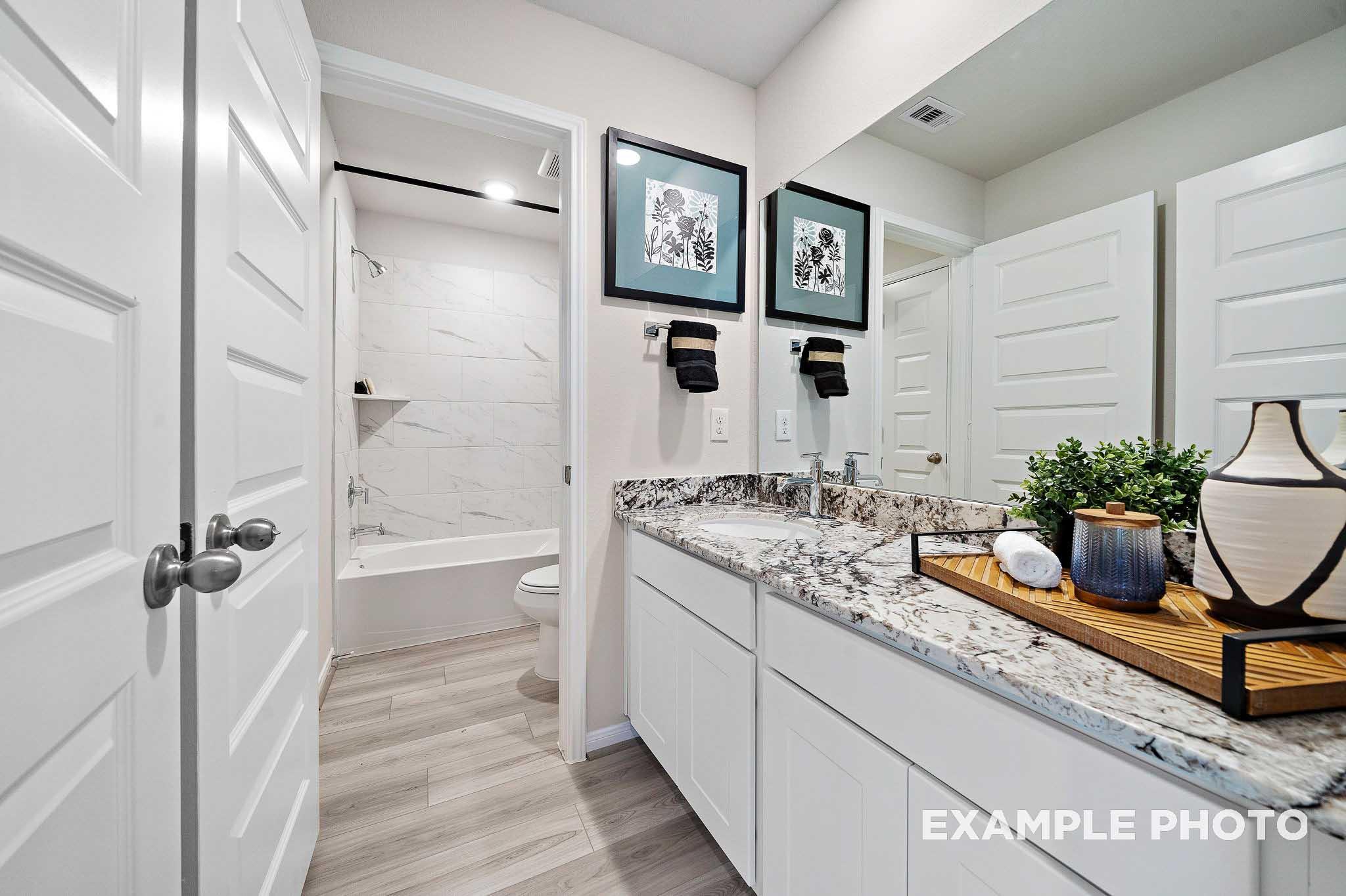 Spacious master bathroom in The San Marcos plan featuring double vanity, freestanding tub, and tiled shower
