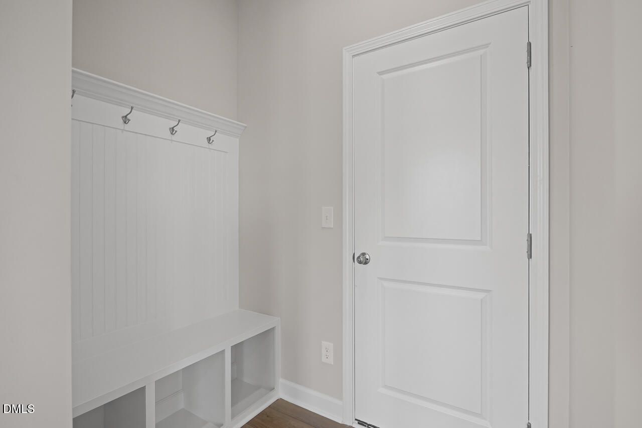 White mudroom bench with coat hooks in The Chestnut floor plan at Wendell Ridge, Wendell, North Carolina.