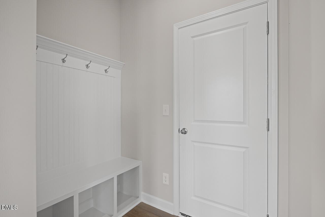 White mudroom bench with coat hooks in The Chestnut floor plan at Wendell Ridge, Wendell, North Carolina.