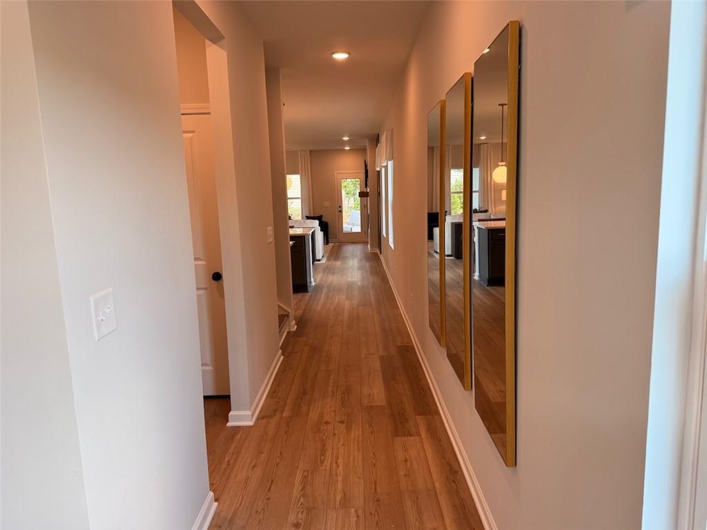 Hallway with hardwood floors and gold-framed mirrors in Davidson Homes The Pinecrest J, Greene Farm, Cartersville, Georgia