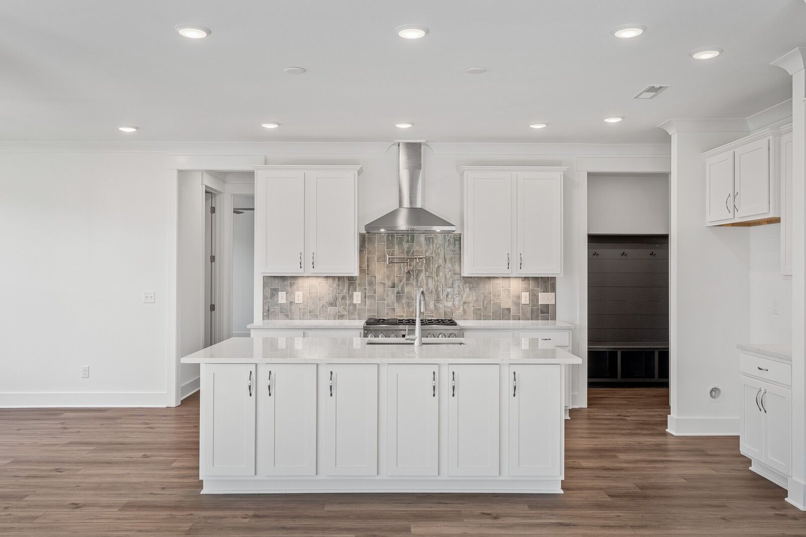 Modern white kitchen with center island, gas cooktop, subway tile backsplash in Davidson Homes The Hawkins, Murfreesboro, TN