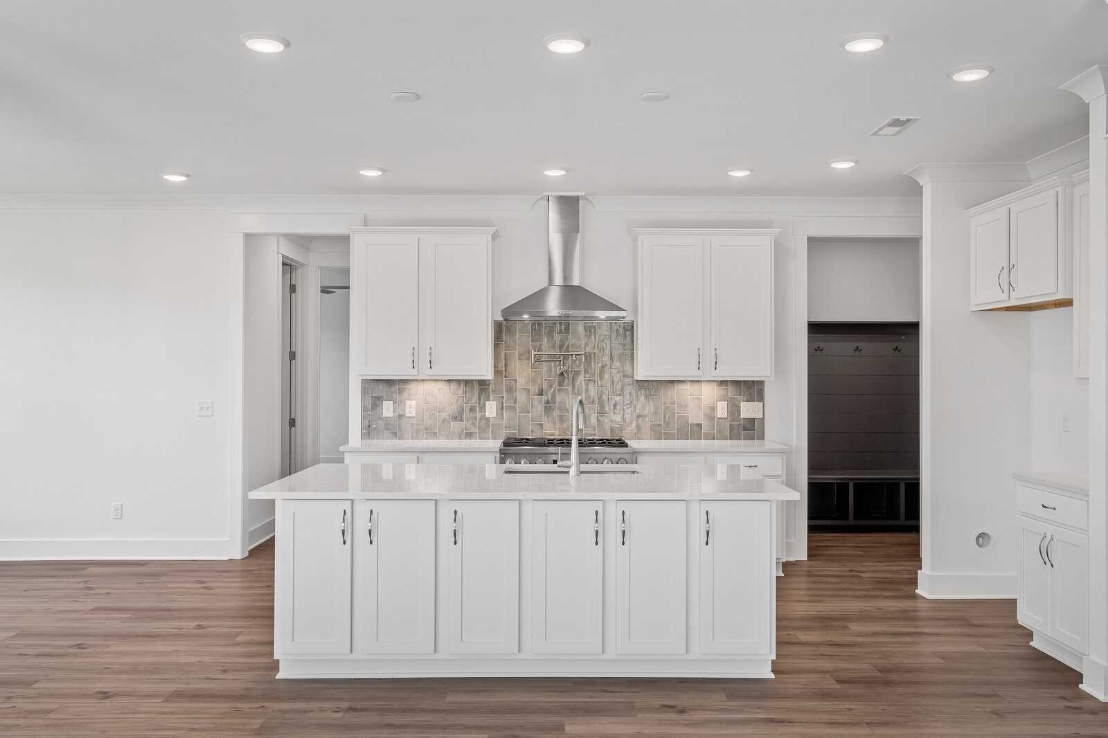 Modern white kitchen with center island, gas cooktop, subway tile backsplash in Davidson Homes The Hawkins, Murfreesboro, TN