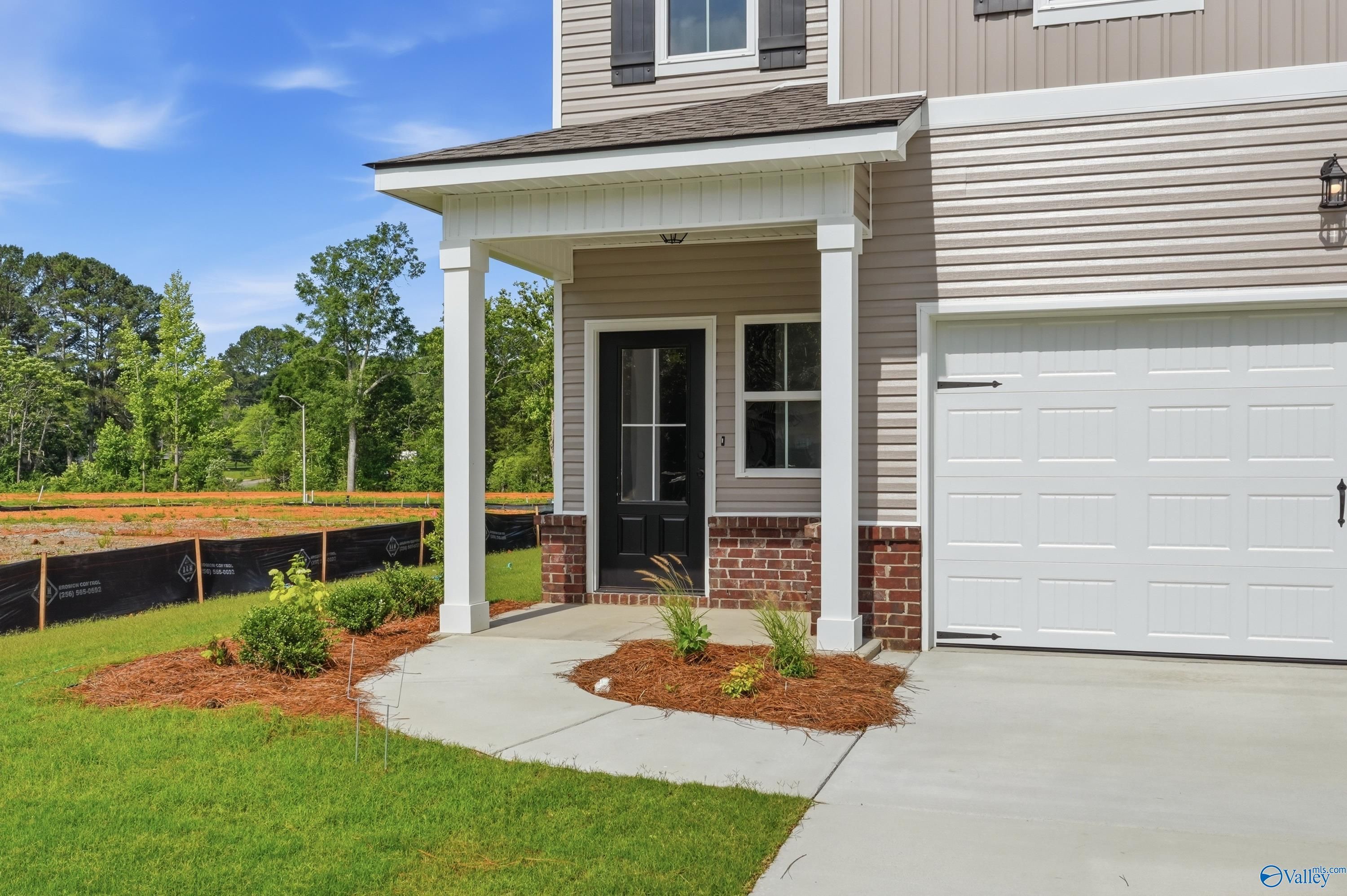 Front exterior of The Russell A floor plan by Davidson Homes in Spragins Cove, Huntsville, Alabama with 2-car garage.