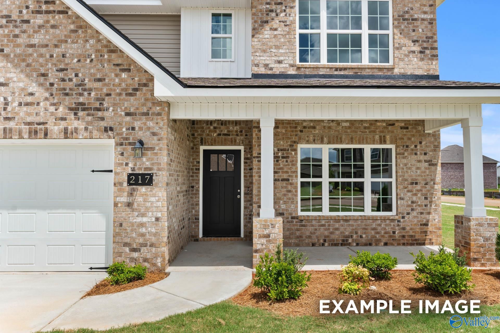 Two-story brick home with 2-car garage, covered porch, black door, and landscaped yard in Ivy Hills, Toney, Alabama - Davidson Homes Chelsea B