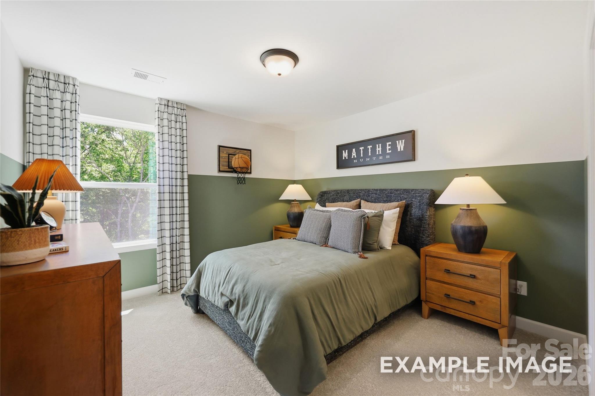 Cozy bedroom with green accent walls, wood nightstands, and plush bedding in The Aspen B floor plan at Windgate, Mooresville, NC