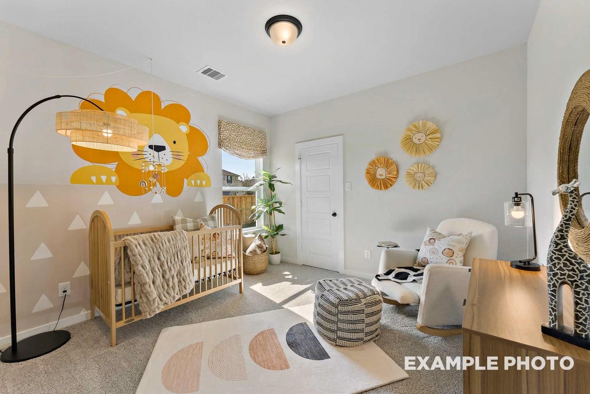 Charming nursery featuring wooden crib, yellow lion wall decal, rattan lamp and giraffe decor in Davidson Homes The Everett C, Dayton Texas