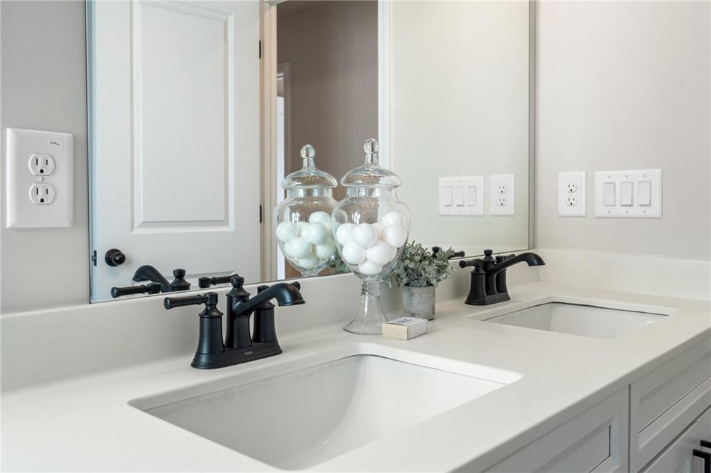 Modern double vanity with undermount sinks, black faucets, and decorative jars in master bath of Davidson Homes The Marion B, Kennesaw, GA