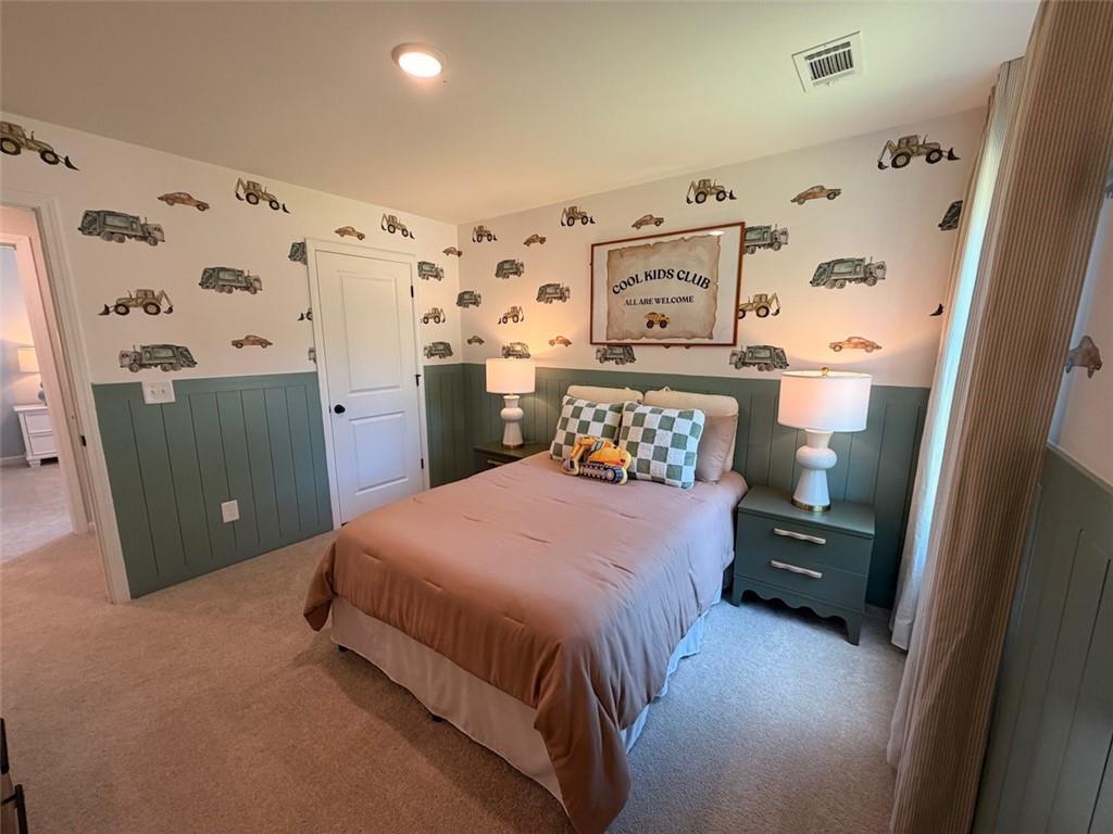 Cozy bedroom with truck-themed wallpaper and green wainscoting in Davidson Homes Pinecrest J, Greene Farm, Cartersville, Georgia