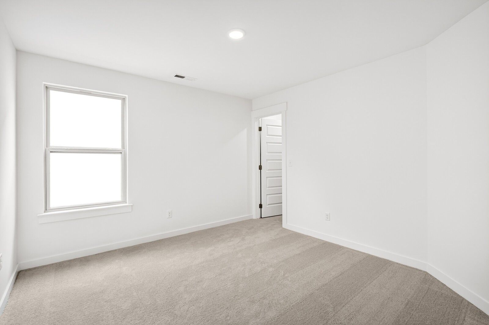 Bright empty bedroom with large window, white walls, and beige carpet in Davidson Homes The Ridgeport C, Gallatin, TN