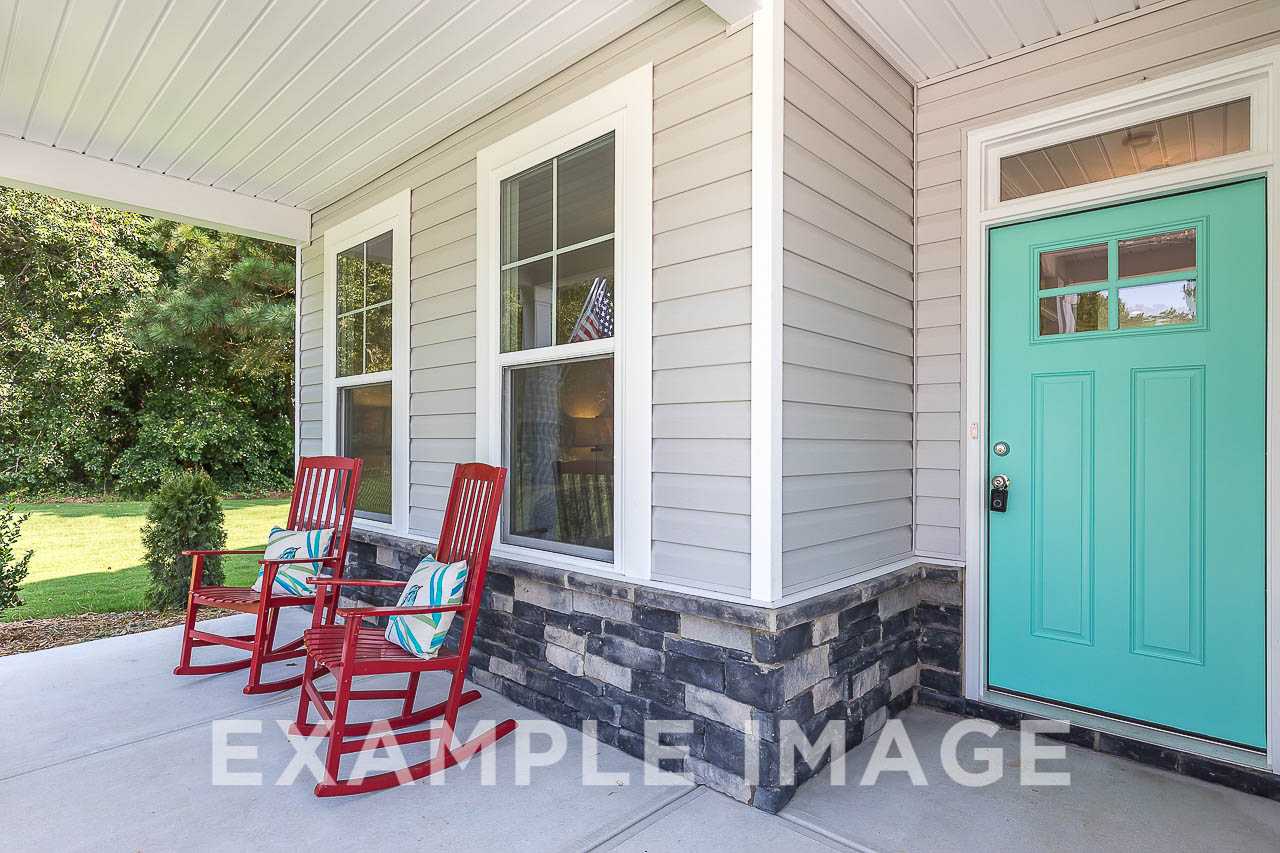 Davidson Homes the Chestnut Plan Front Porch with stone accents, red rocking chairs and teal colored front door