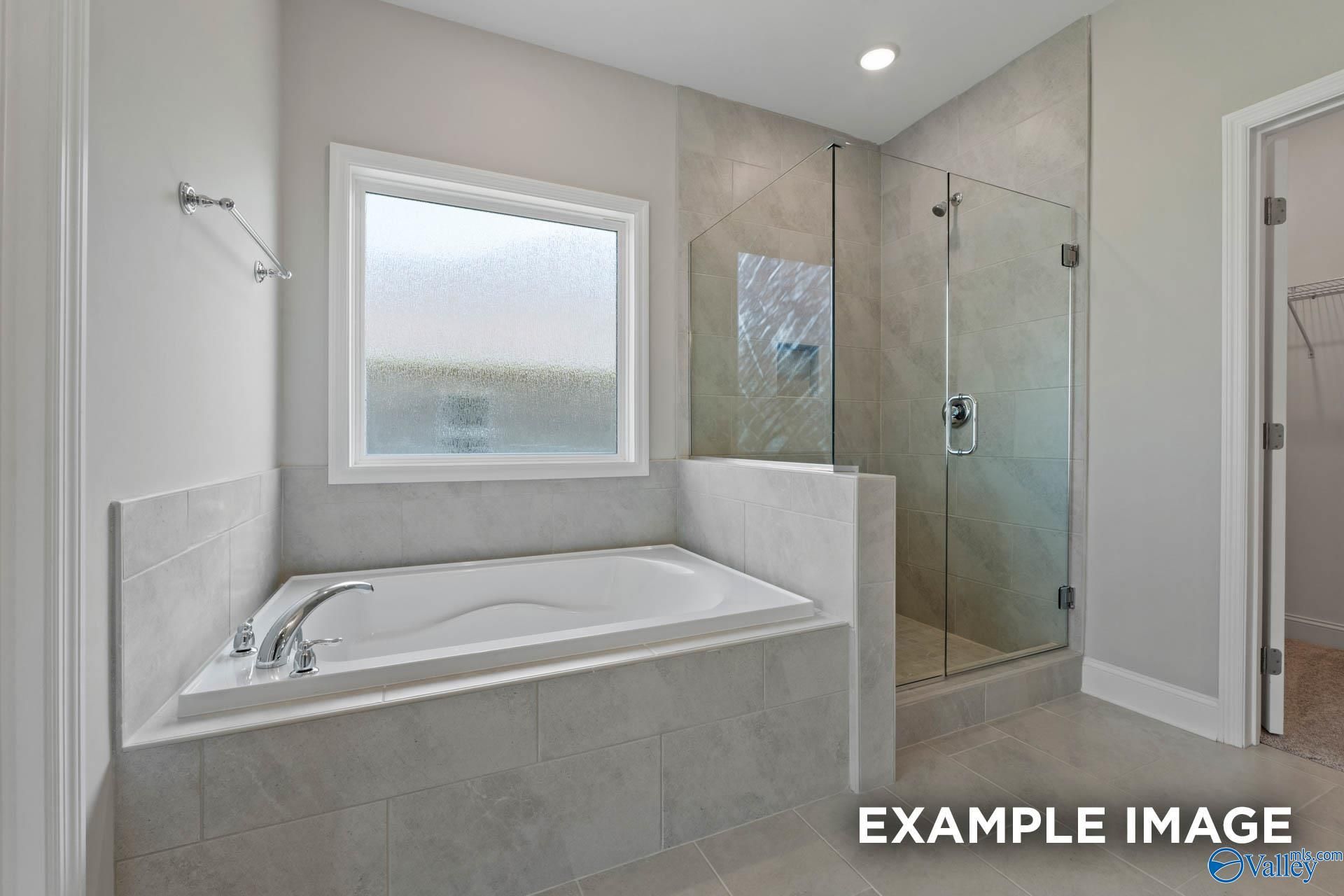 Modern master bathroom featuring freestanding tub and glass shower in Davidson Homes The Montgomery B, Hartselle, Alabama
