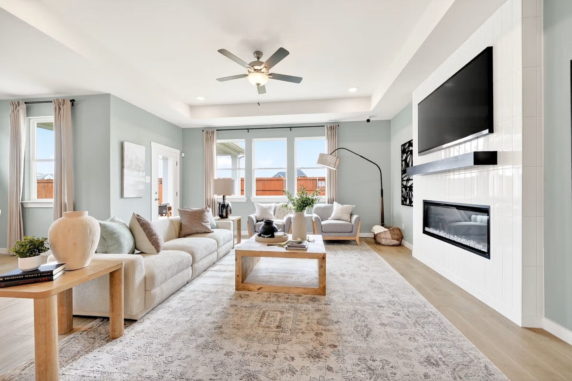 Bright, open-concept living room with fireplace and tray ceiling in The Laurel I floor plan by Davidson Homes in Heartland.