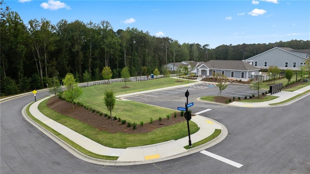 Aerial view of Kelly Preserve clubhouse with lush landscaping, parking lots, and new homes in Loganville, Georgia