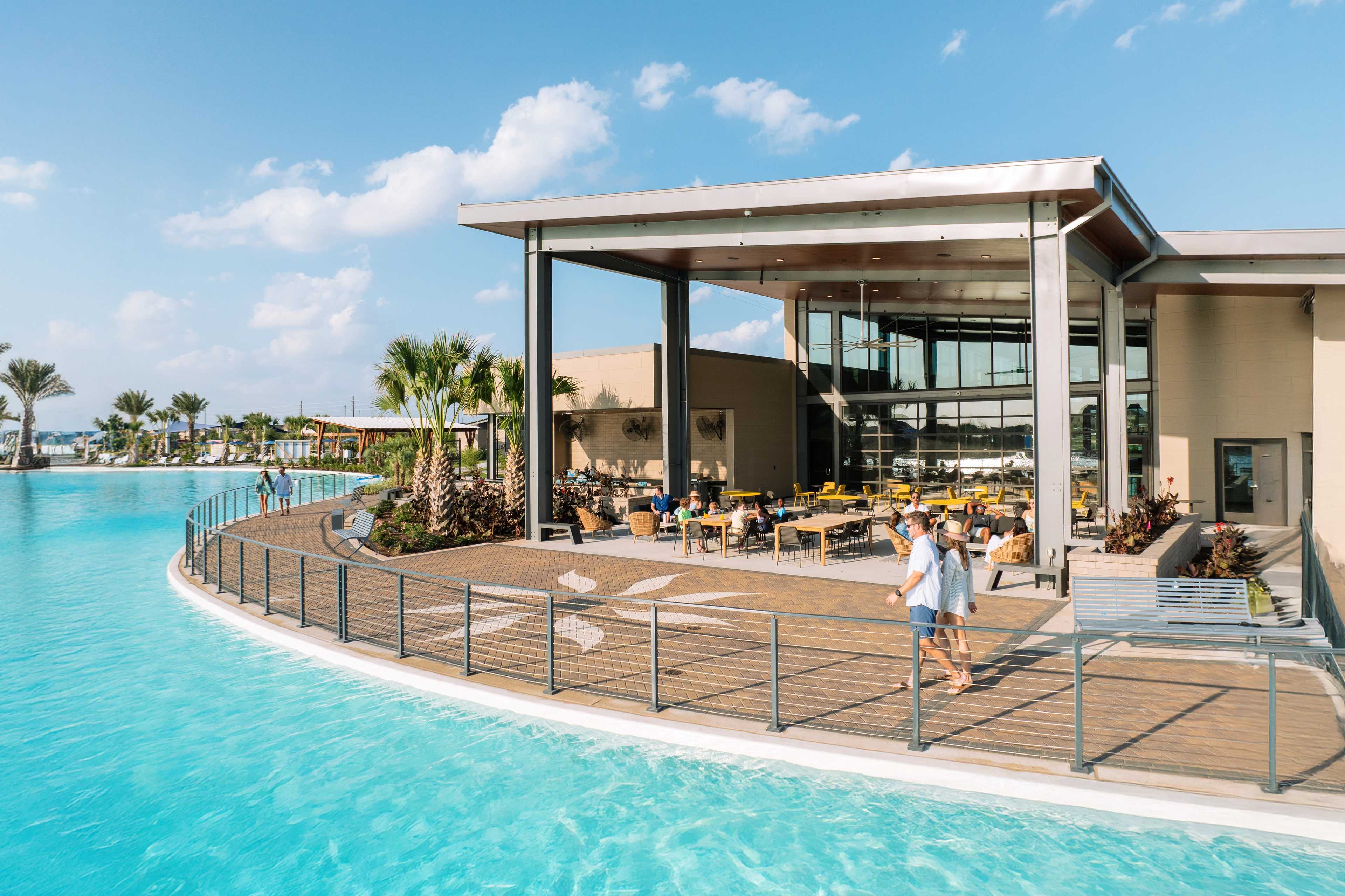 Resort-style infinity pool at Sunterra in Katy Texas with covered pavilion, wooden deck and lounge seating