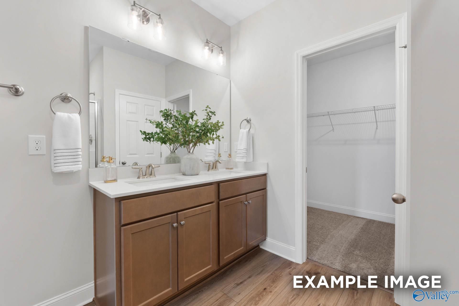 Double vanity bathroom with wood cabinets and walk-in closet in The Franklin C floor plan, Heritage Lakes, New Market.