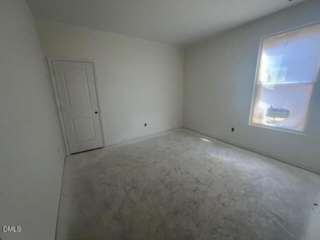 Empty bedroom with fresh white paint, closet door, and sunlit window in Davidson Homes Magnolia II B plan, Lillington, NC