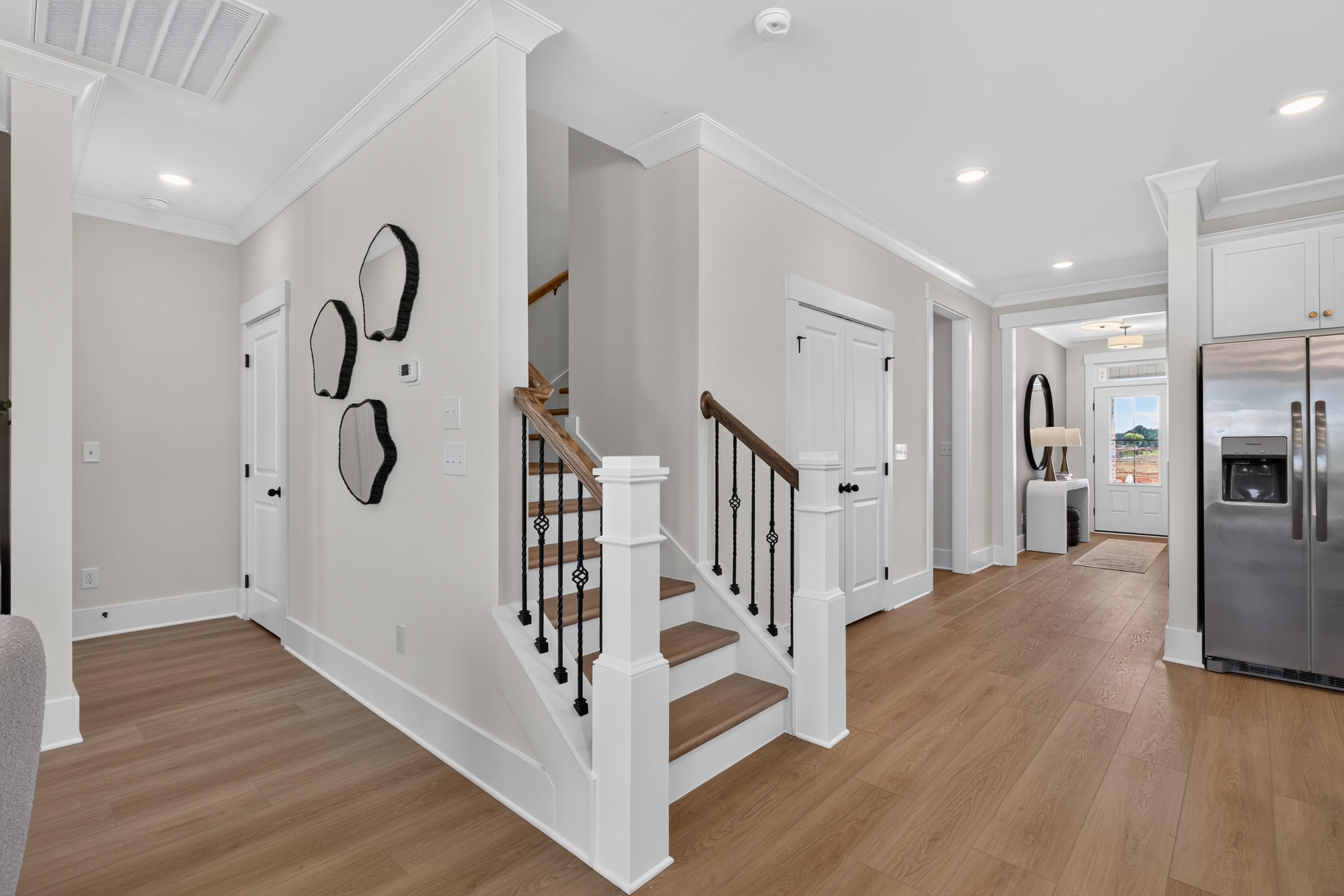 Open foyer with staircase, hardwood floors, and stainless steel appliances at Evergreen Mill by Davidson Homes in Madison, AL