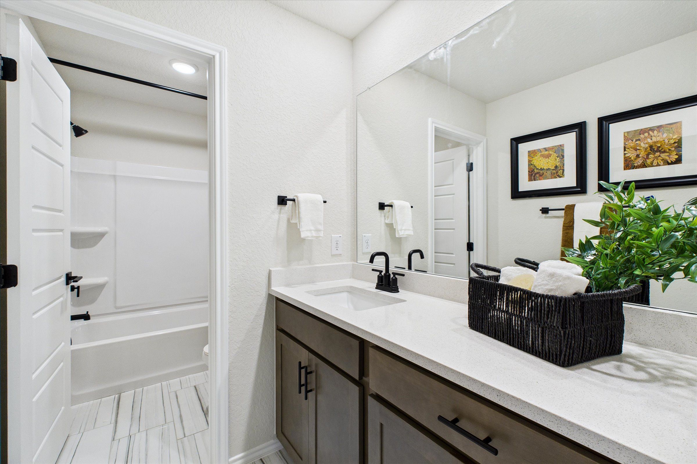 Contemporary bathroom with double vanity, quartz countertop, and open tub at Meadows at Oak Creek in San Antonio TX