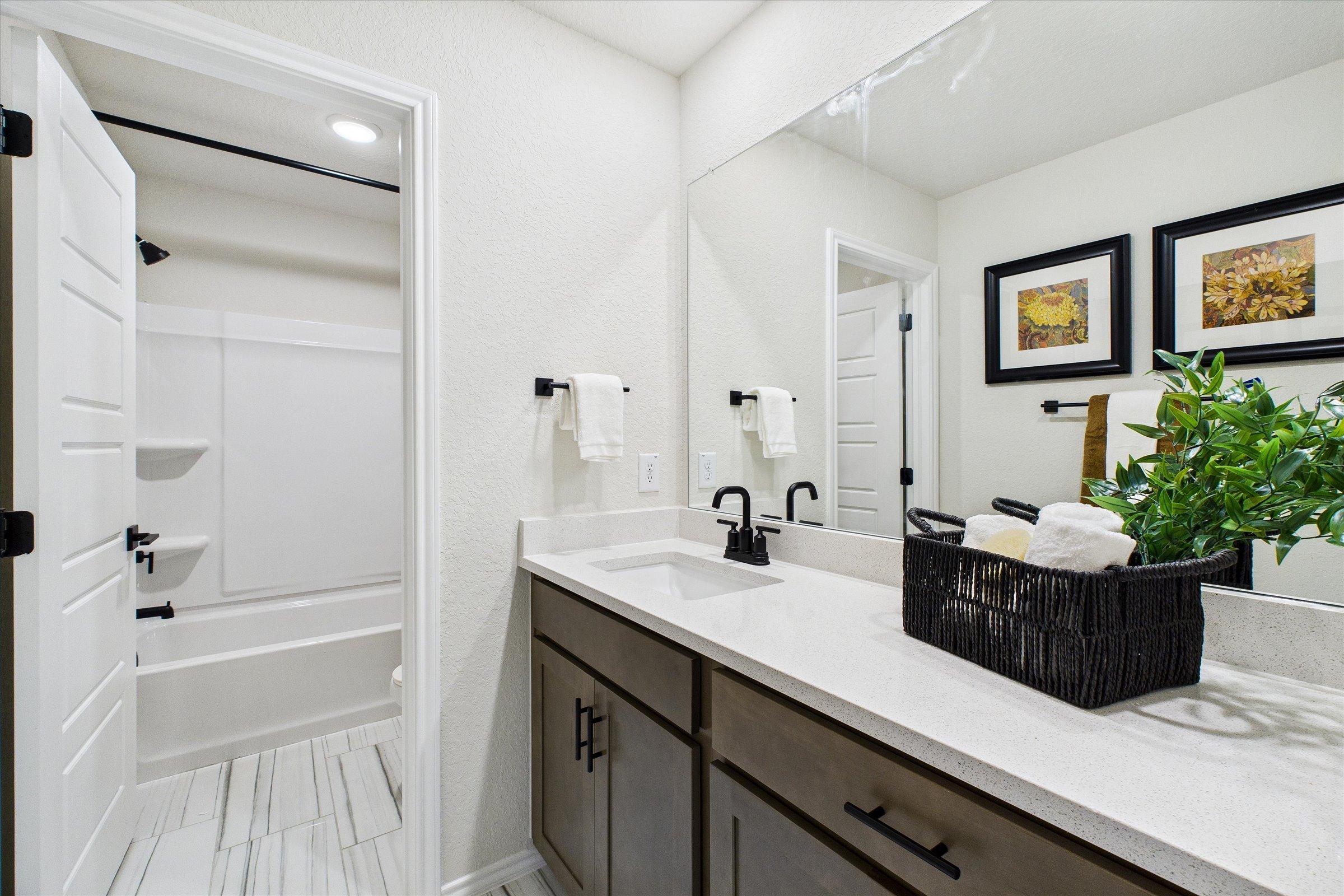 Contemporary bathroom with double vanity, quartz countertop, and open tub at Meadows at Oak Creek in San Antonio TX