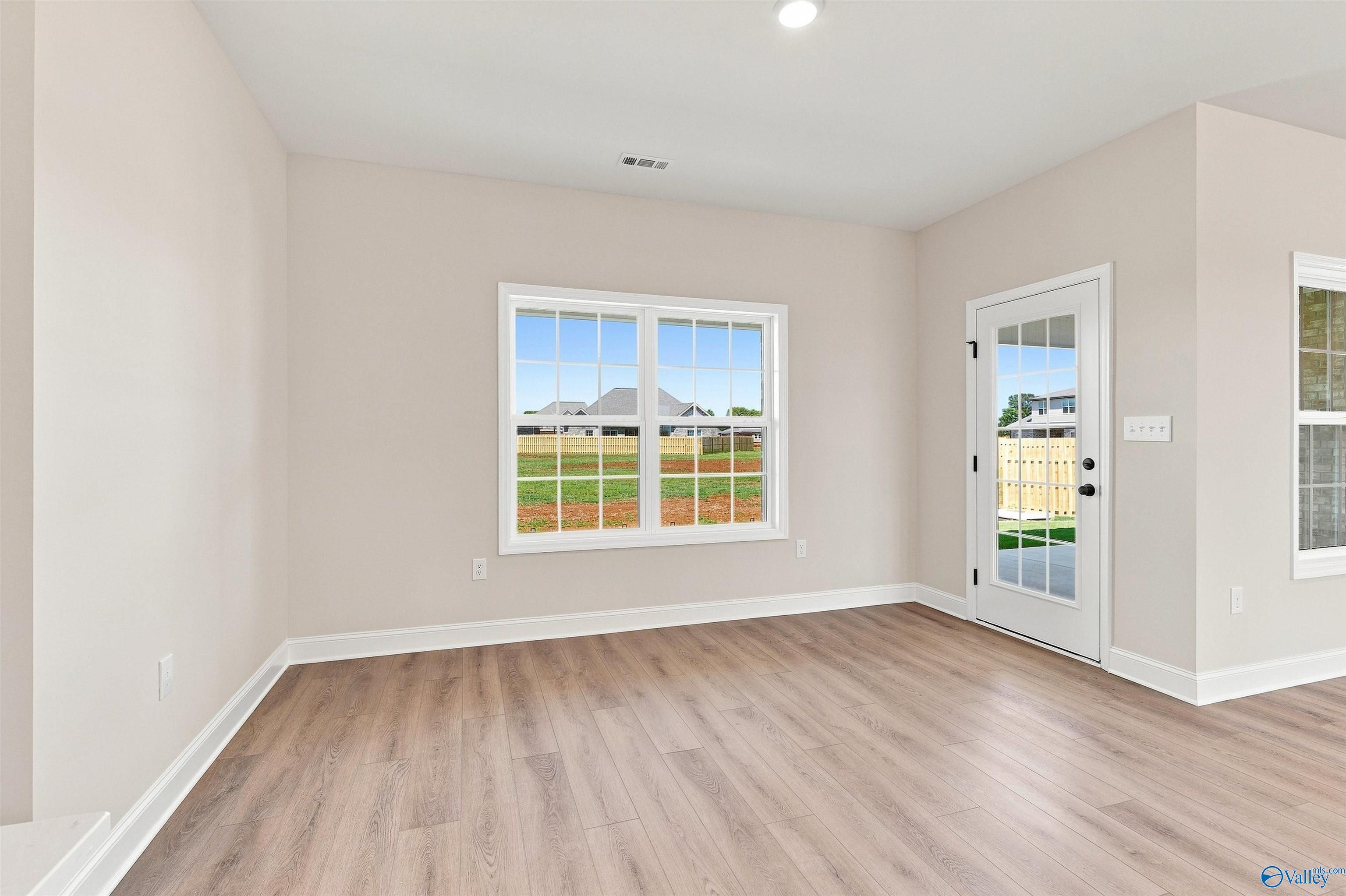 Bright breakfast nook with wood-look flooring and backyard views in The Oxford floor plan, Kendall Farms, Toney, Alabama.