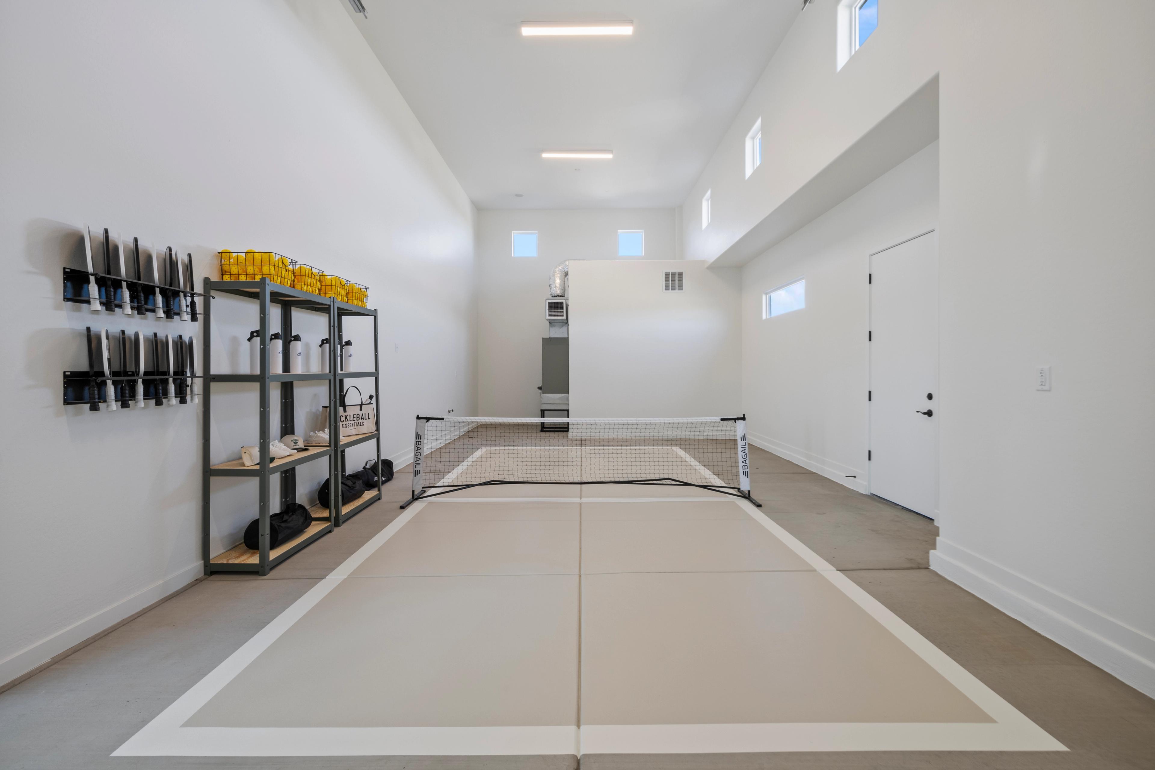 Indoor pickleball court in Hidden Hills garage by Davidson Homes Prescott AZ with net, storage shelves, and marked flooring