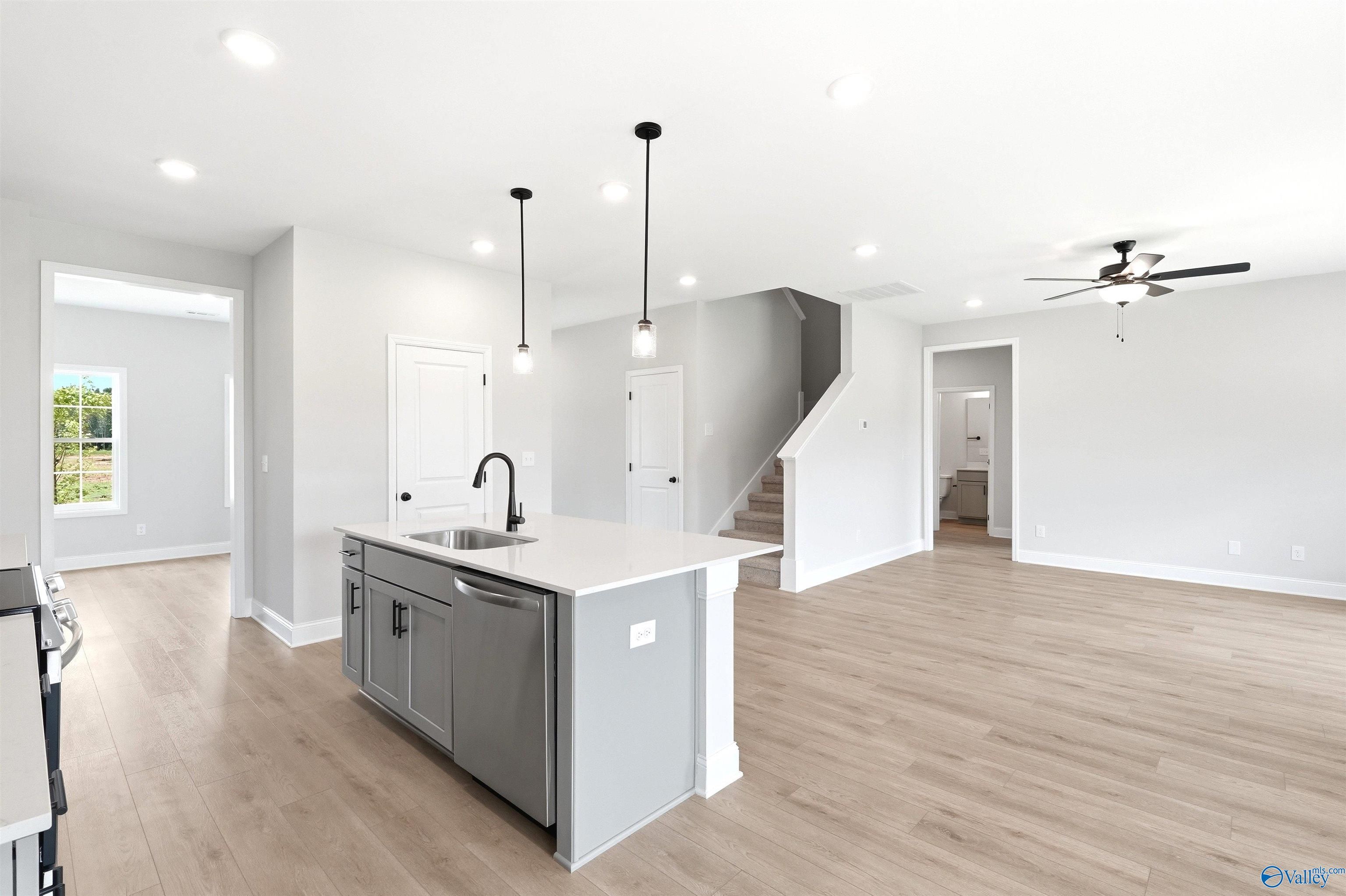 Modern open-concept kitchen with center island in The Shelby A floor plan at Wood Trail, Toney, Alabama.