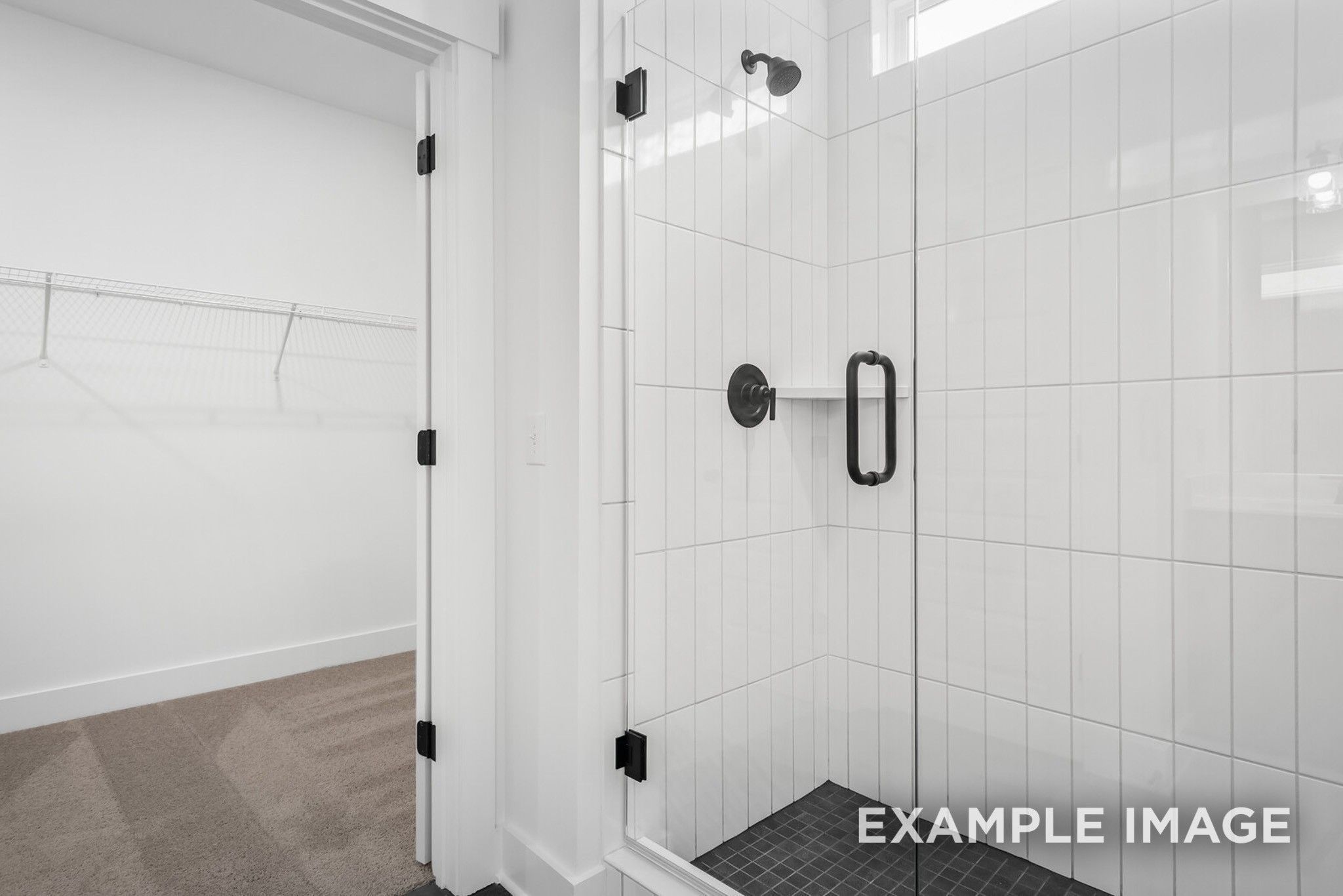 Modern white subway tile walk-in shower with frameless glass door and black fixtures in master bath, Ridgeport C home, Gallatin, TN