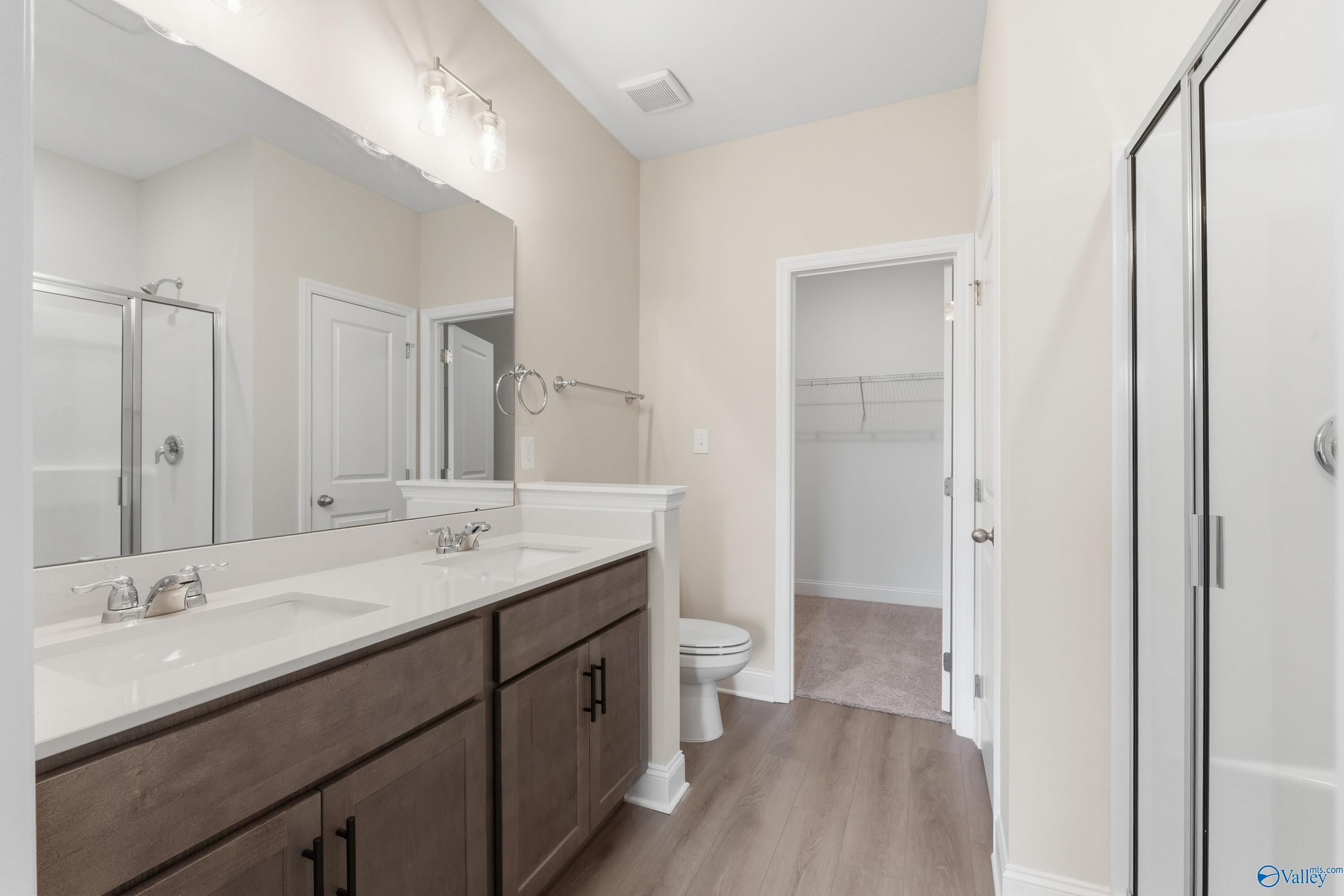 Modern master bathroom featuring double vanity, walk-in shower, and linen closet in Davidson Homes The Asheville C, Huntsville, AL