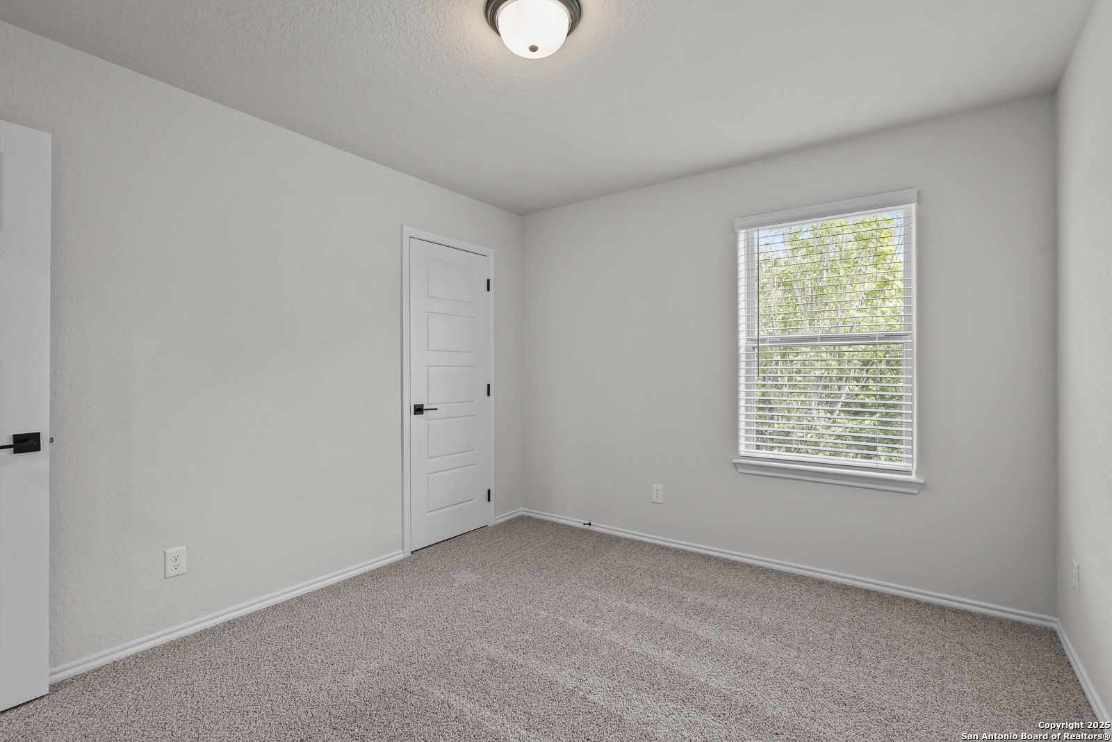 Bright secondary bedroom with gray walls, carpet floor, and window blinds in Davidson Homes The Florence C, San Antonio