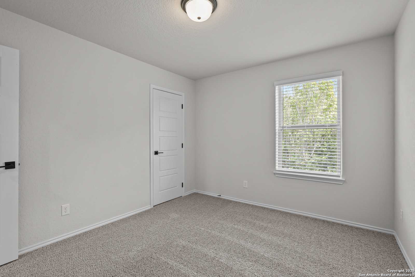 Bright secondary bedroom with gray walls, carpet floor, and window blinds in Davidson Homes The Florence C, San Antonio